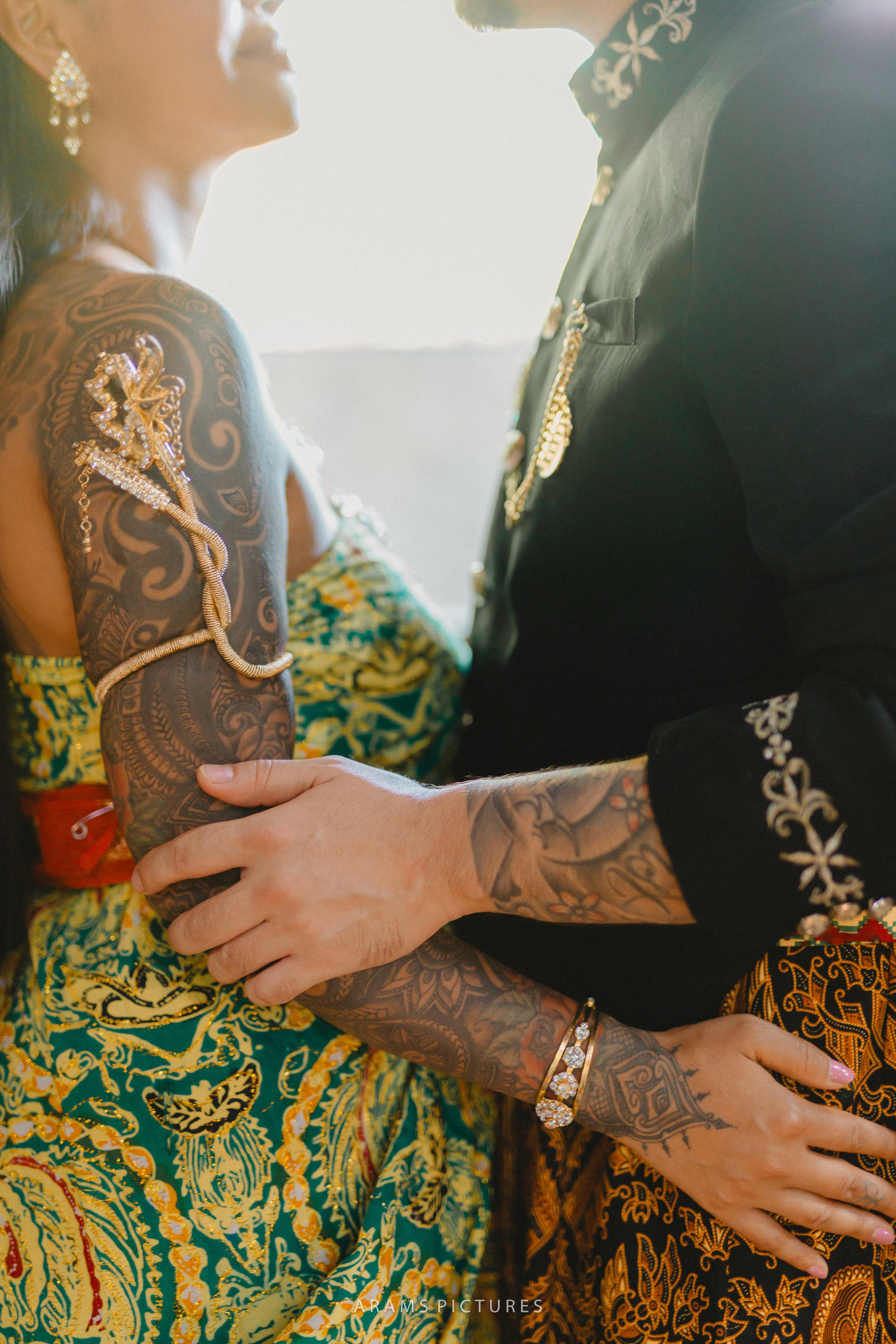 Engaged couple standing with vintage bicycle in Cotswolds countryside flower field