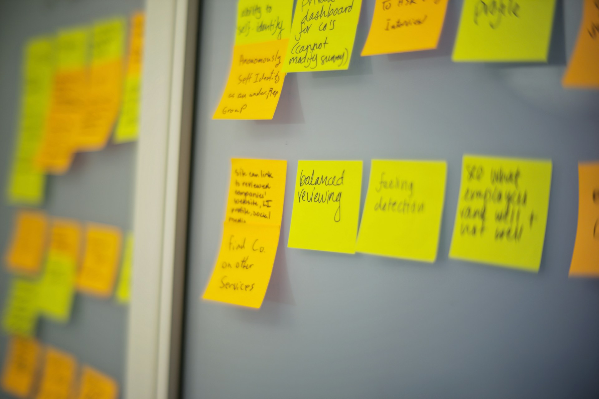A series of post-its in a wall. Each one has a phrase.