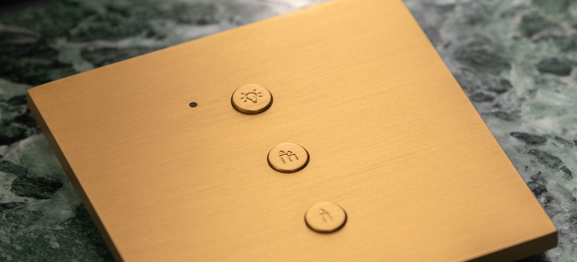 Gold panel with three circular buttons and a dot