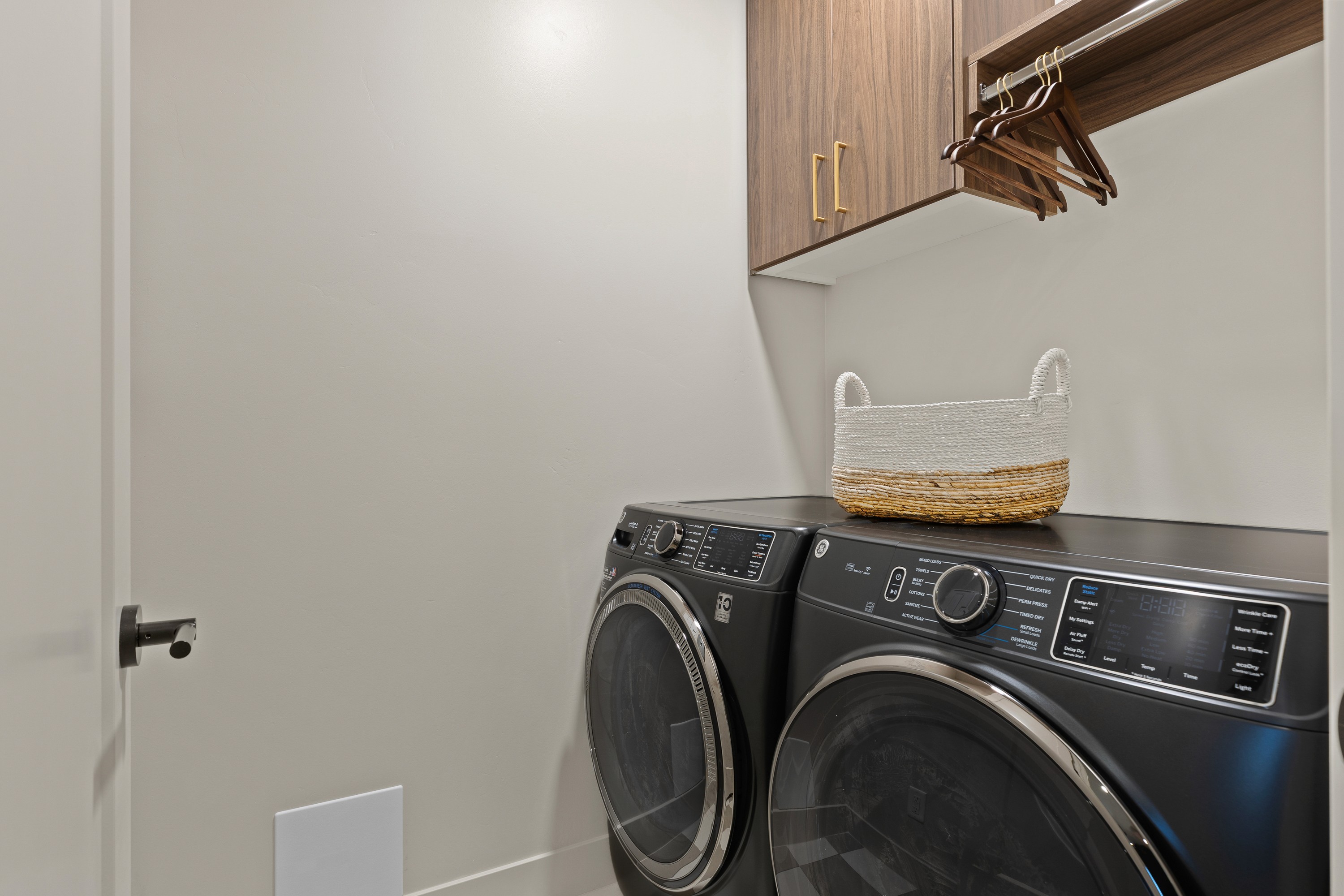 Laundry room inside The Painted Horizon twin home in Hurricane, Utah featuring cabinetry and a functional laundry layout.