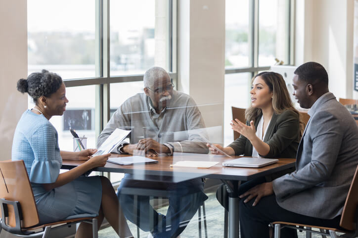A group of people discussing strategies for business growth around a table. Form G-28
