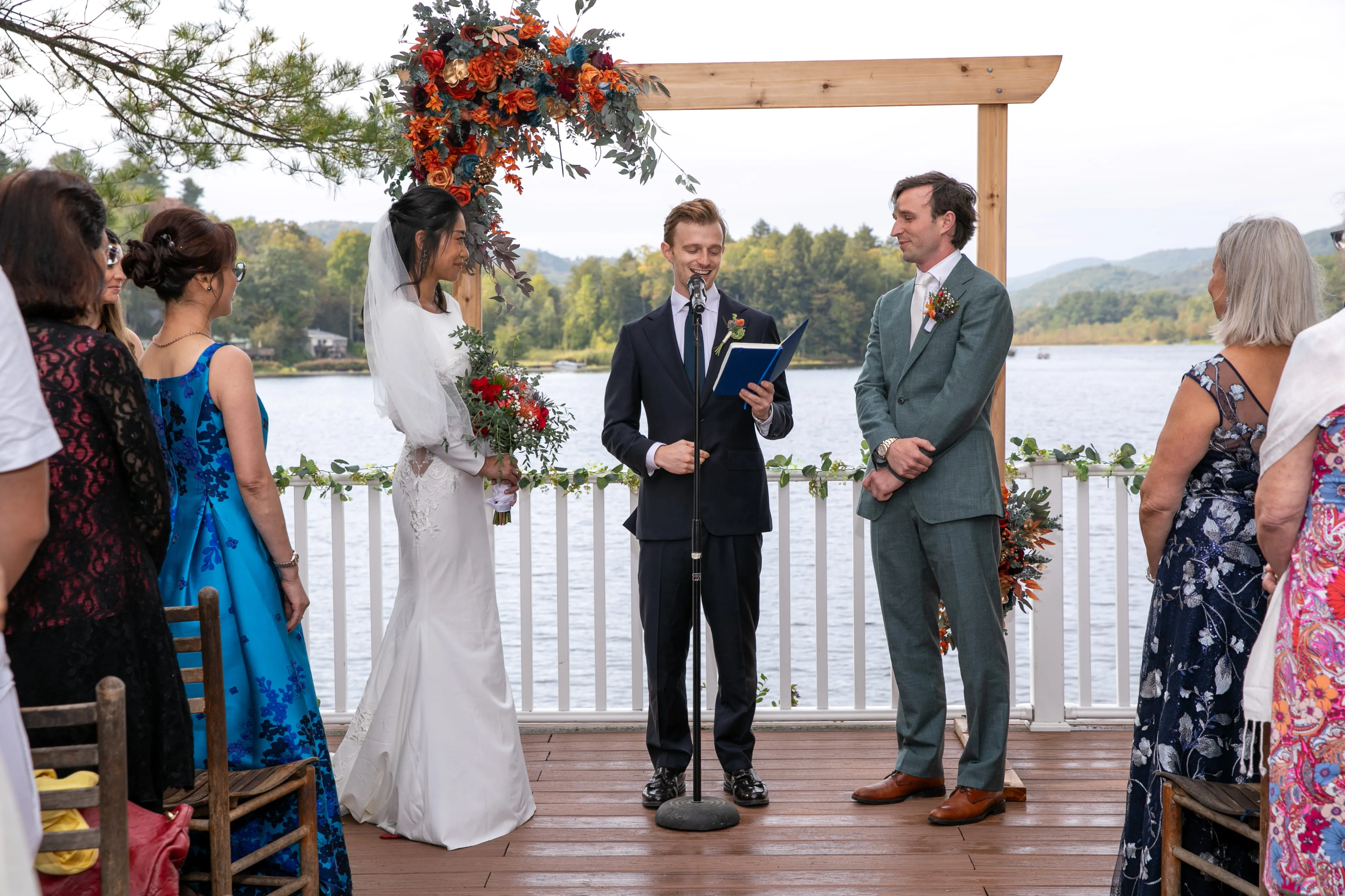 Lakeside wedding ceremony with officiant and couple at Camp Lenox