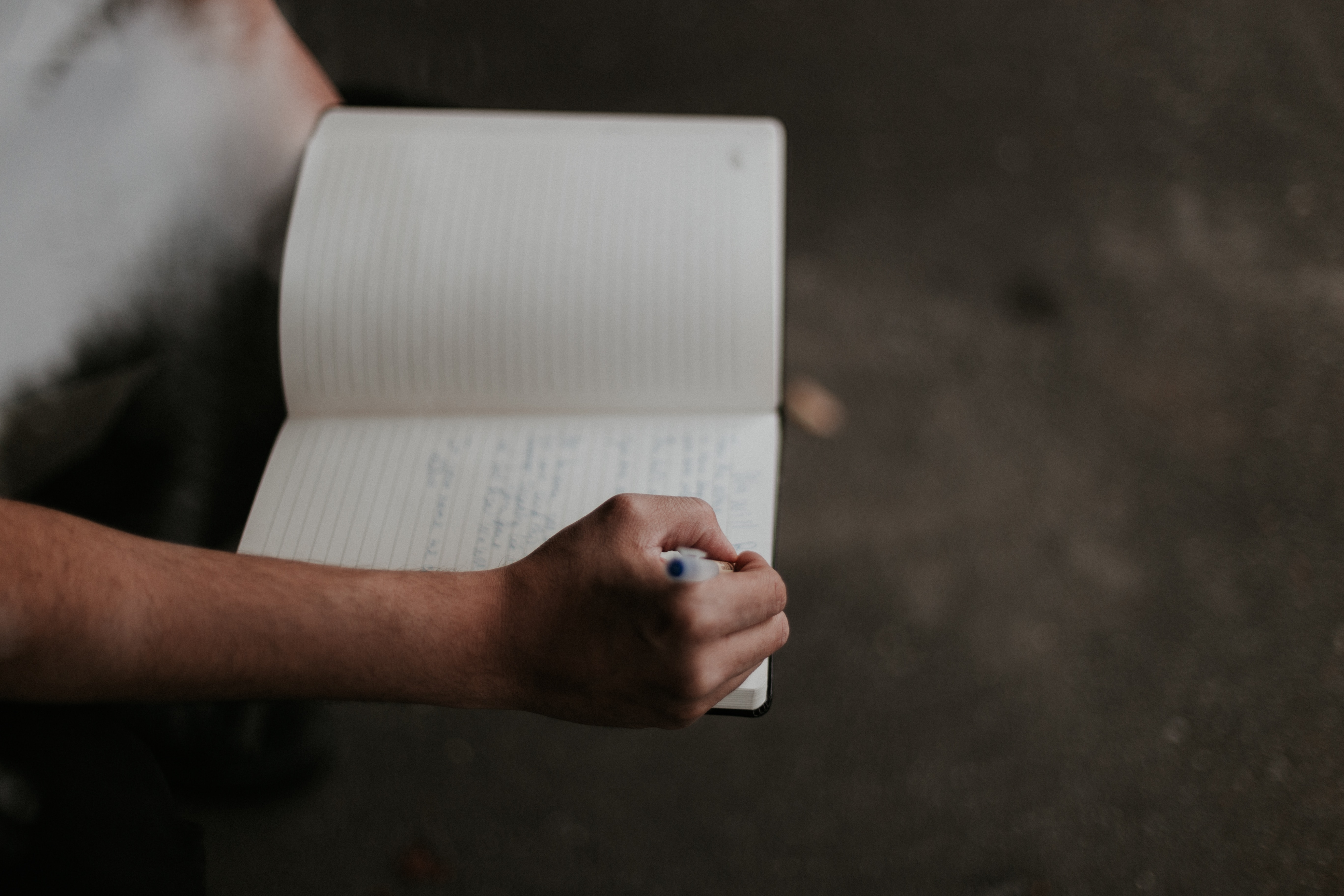 man writing on his notebook - how to write hit songs