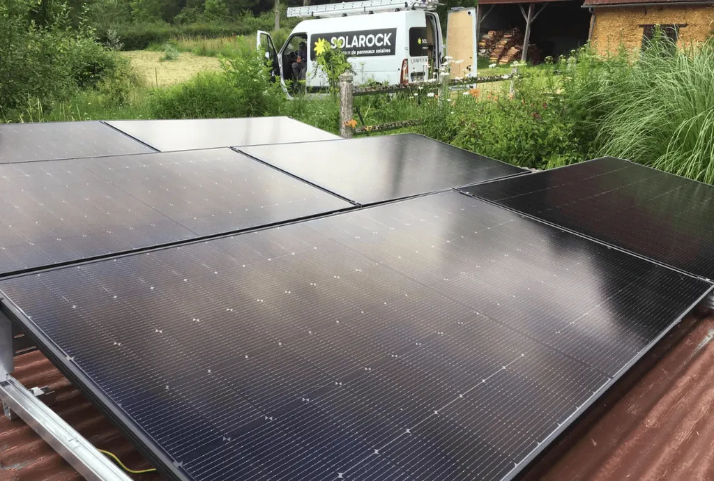 Photo de panneaux photovoltaïques de la marque DualSun qui ont été installés sur le toit d'une dépendence. On voit une maison en construction en arrière plan.