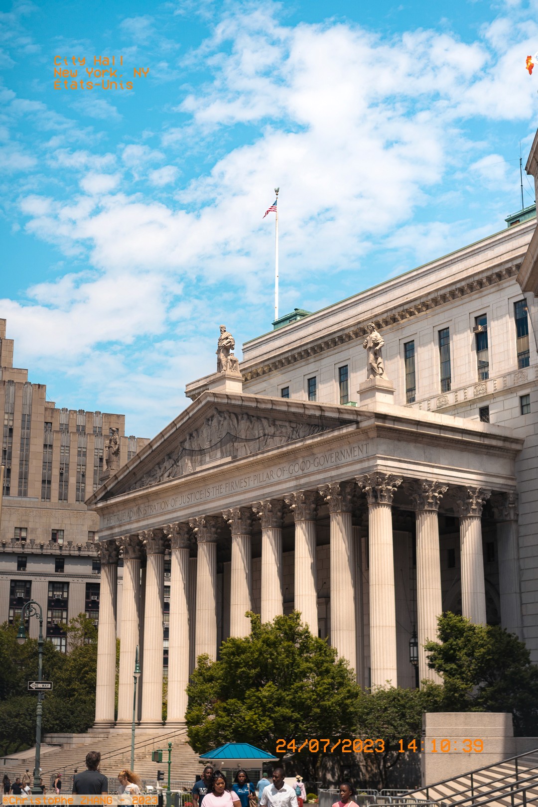 Façade classique du City Hall de New York avec des colonnes imposantes sous un ciel bleu.