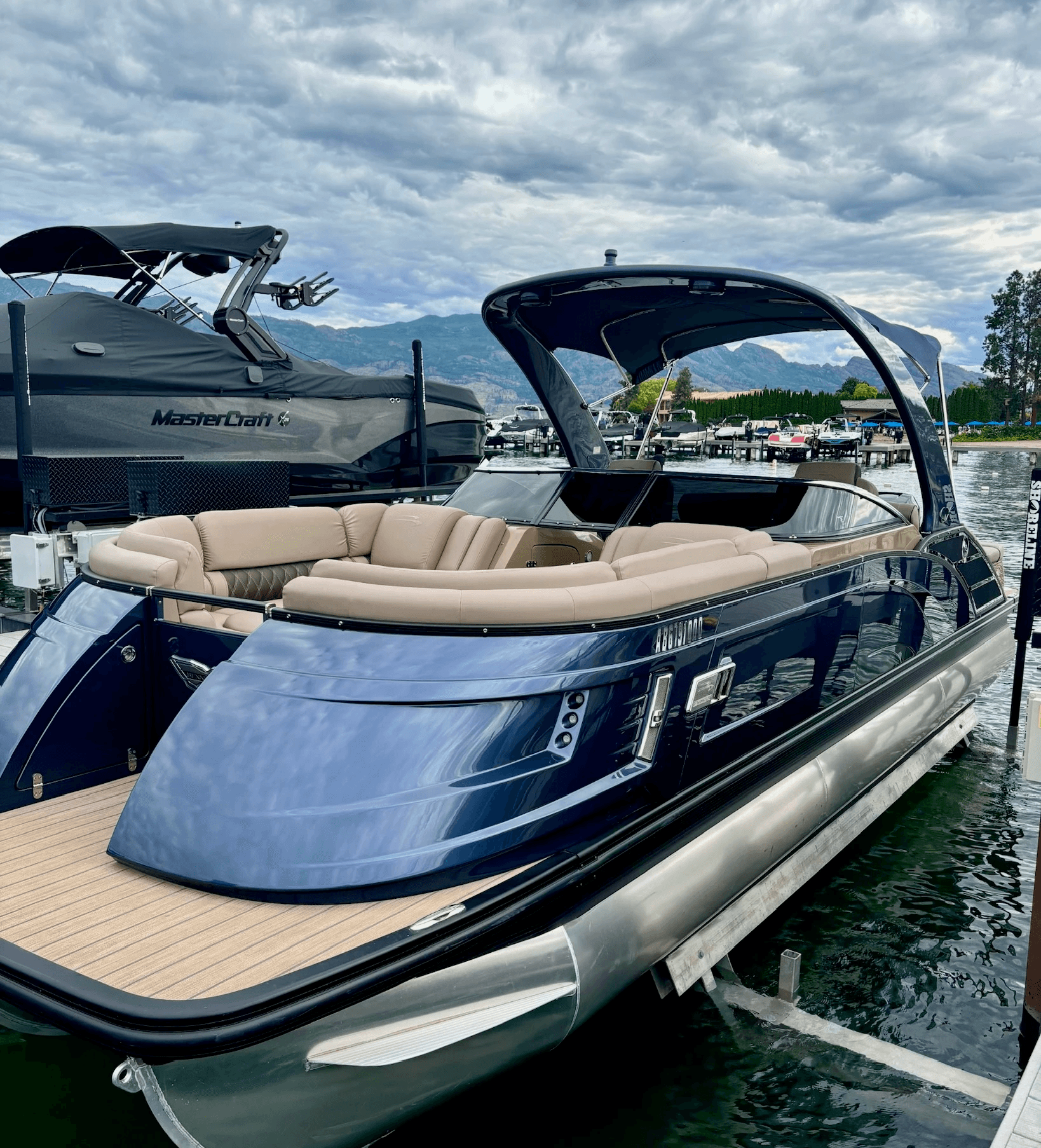 A pontoon parked in a marina slip that has been freshly exterior detailed and looks shiny and perfect