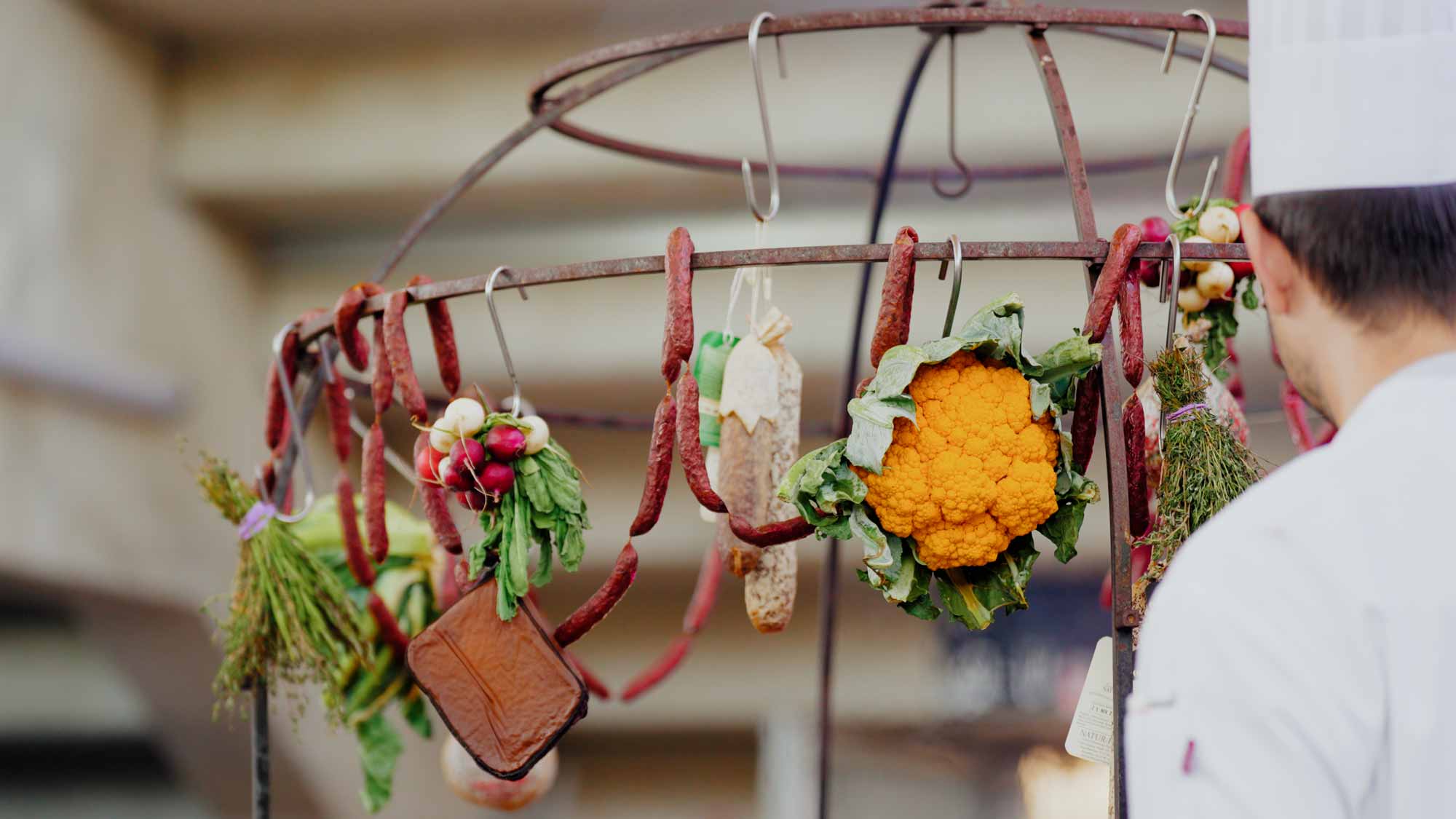 Chef observes colorful food display; ideal for filmproduction, ads, and storytelling in social media campaigns.