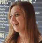 woman staring directly at camera near pink wall