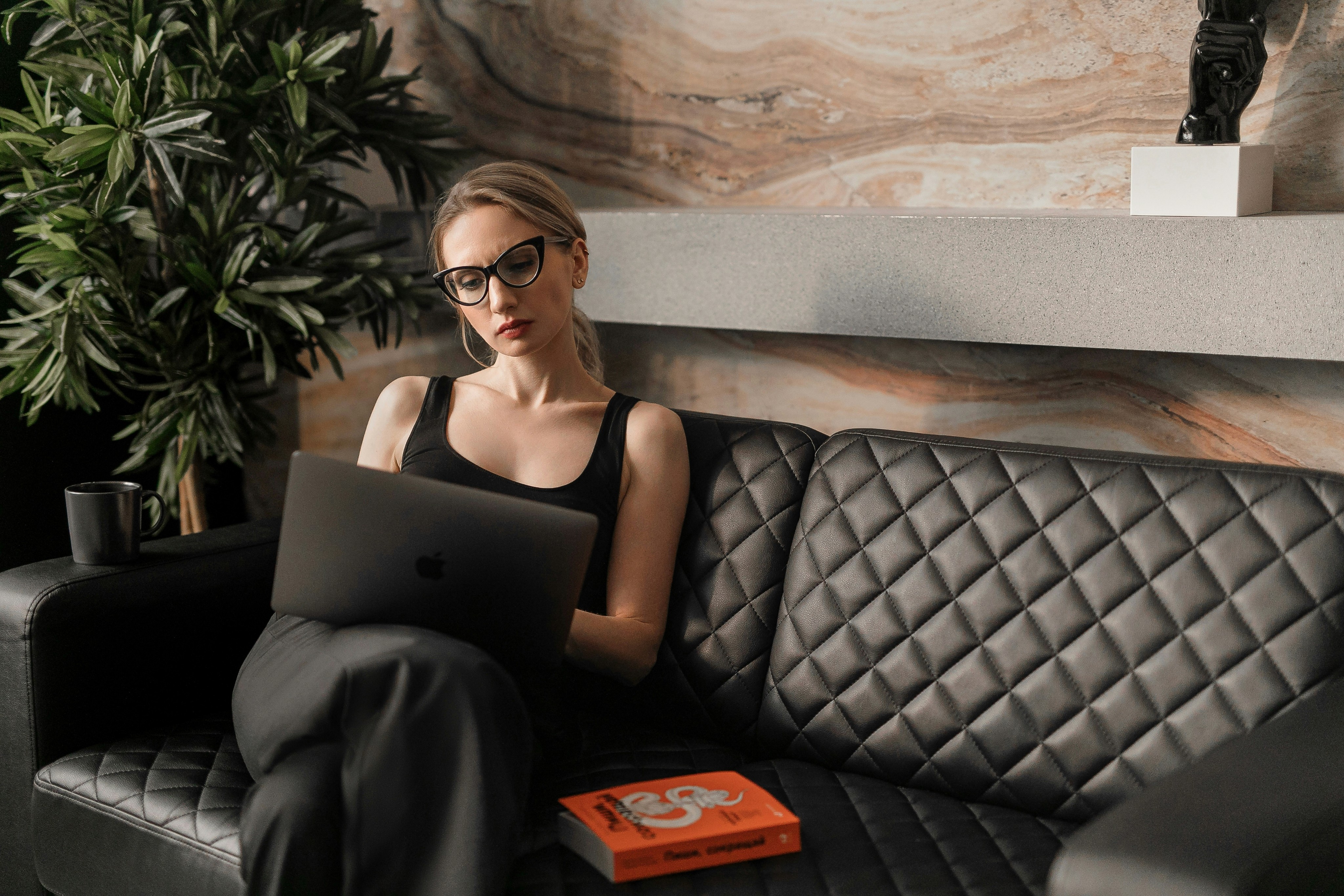 Women sitting on a sofa using her computer.