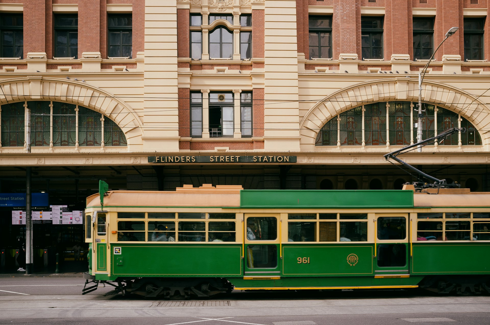 A restaurant interior featuring marble countertops, brown leather chairs, wood-paneled walls, and round pendant lights hanging above a bar set with wine glasses.