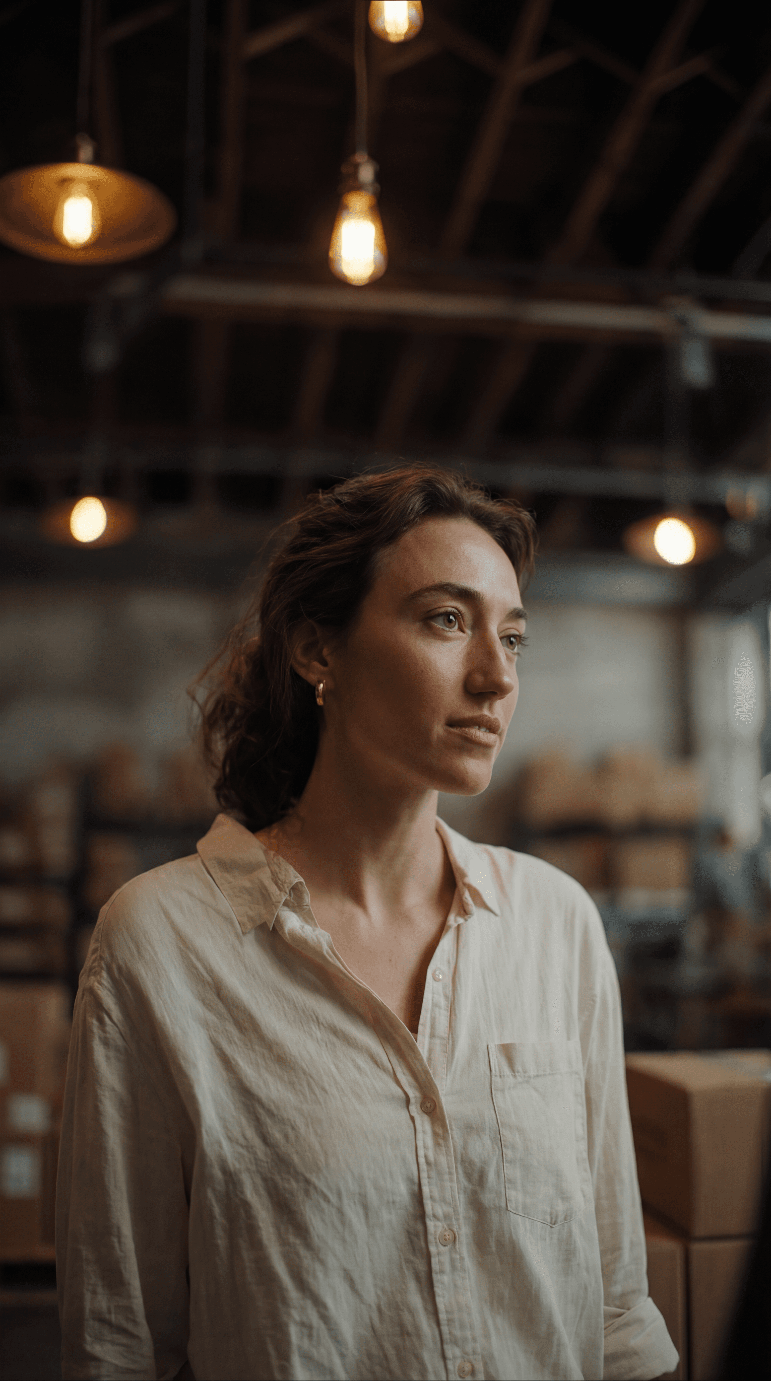 Female scientist wearing a white coat and gloves examines a sample slide in a modern laboratory setting.