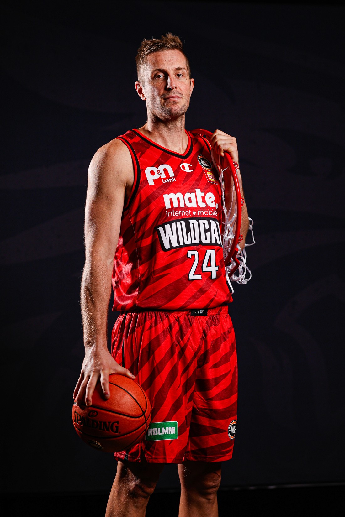 Perth Wildcats player wearing the redesigned number 24 jersey, holding a basketball and net