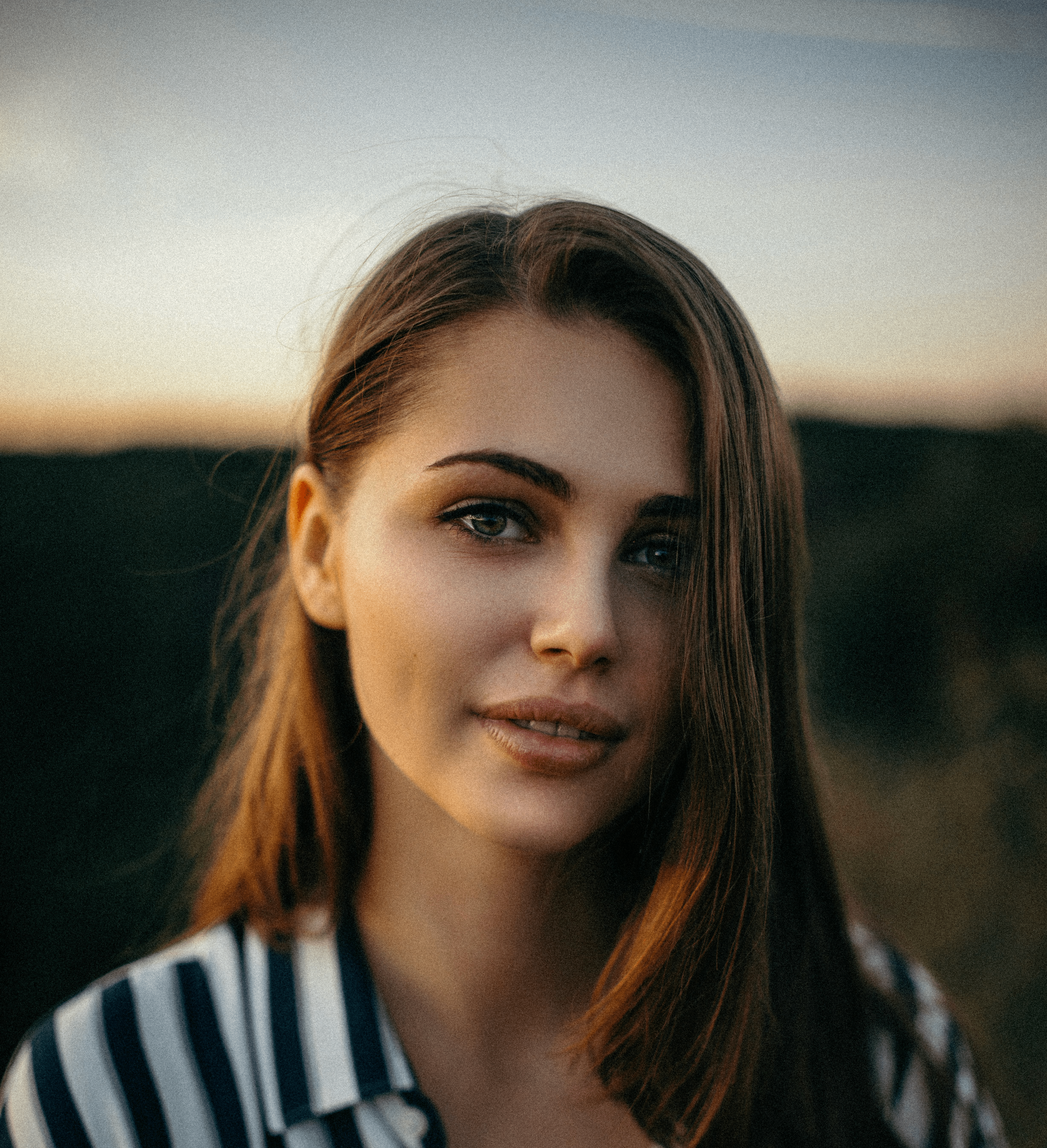 smiling woman wearing white and black pinstriped collared top
