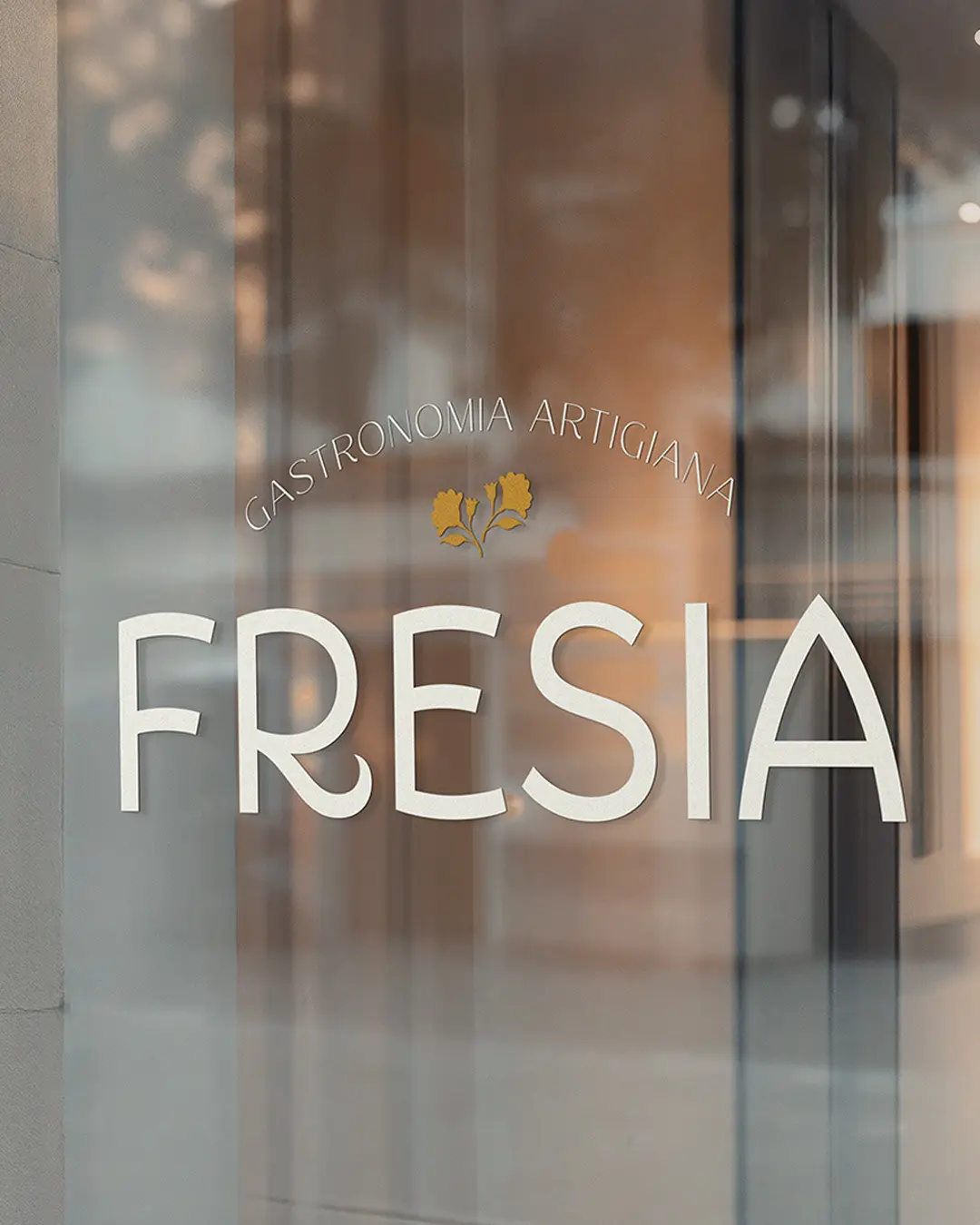photo of a restaurant window lettering with the word Fresia
