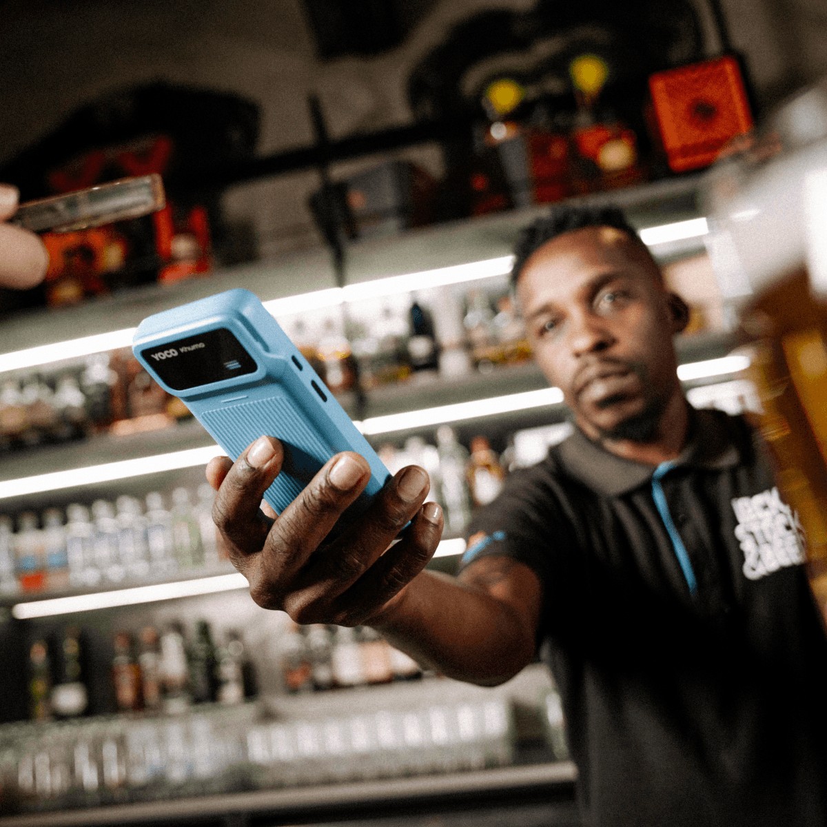 A man holds out the Khumo 2 machine to receive a payment