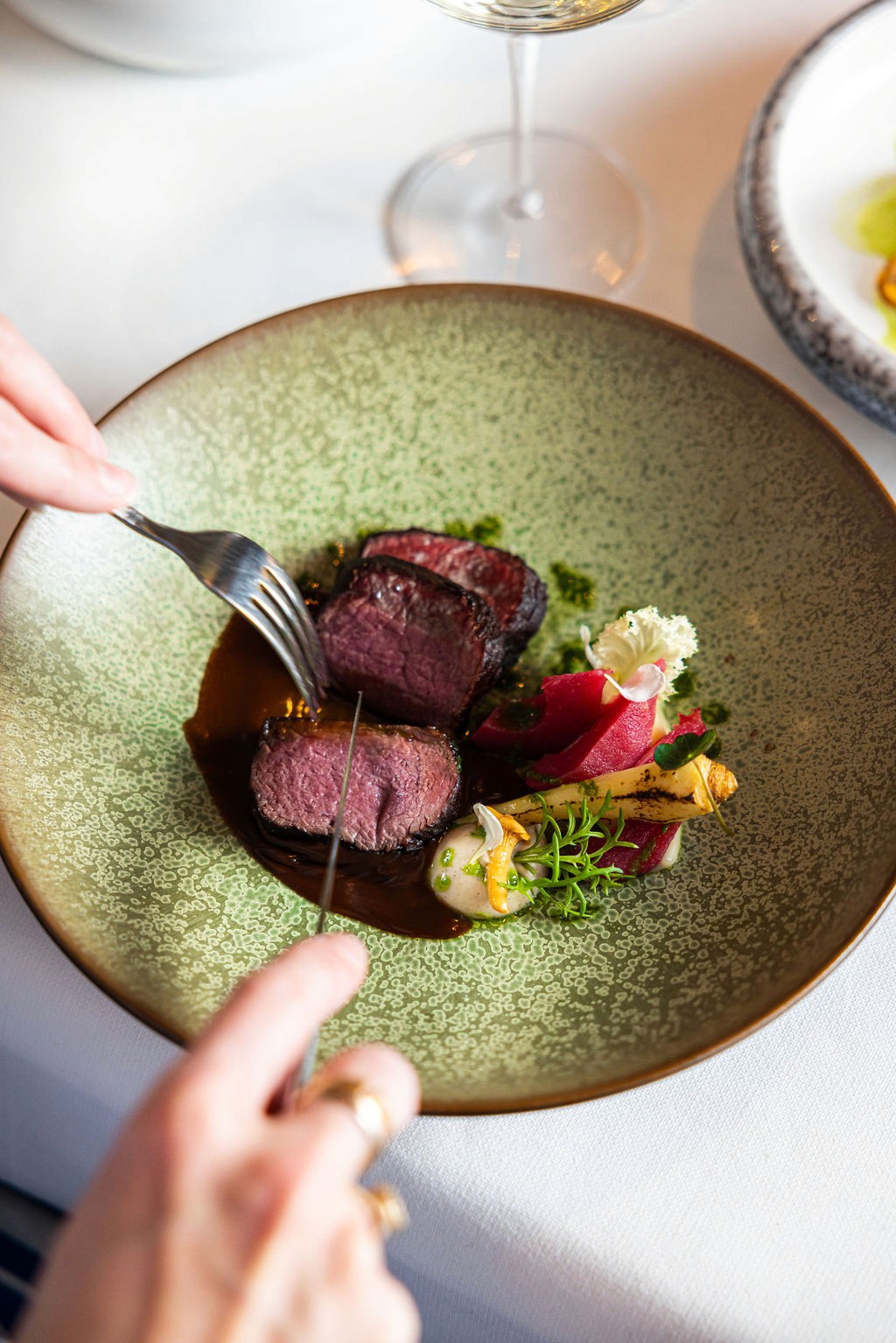 man's hand pouring red wint into a glass