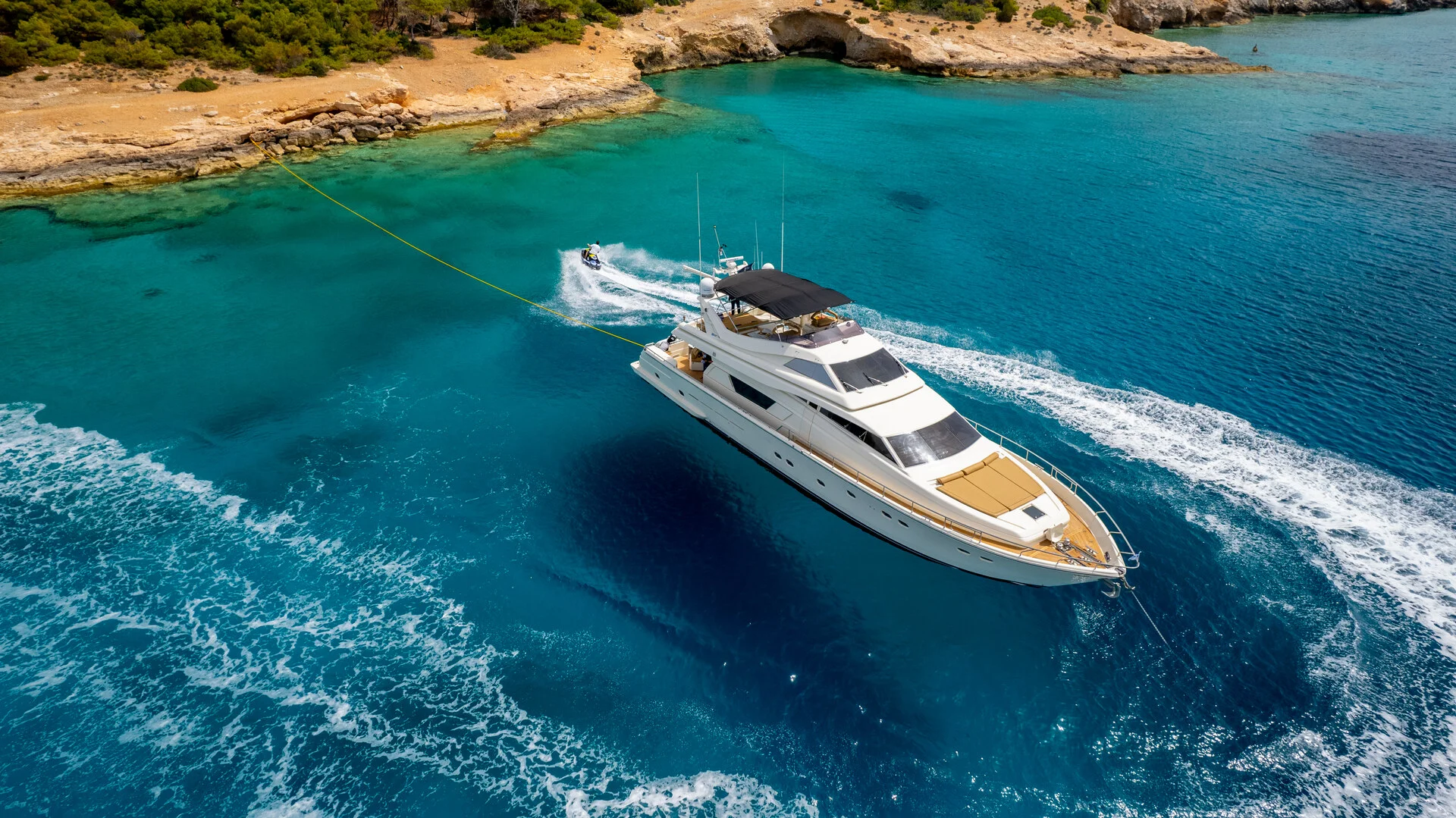 White Rock 36 speedboat with captain at helm cruising calm blue waters near Paros coastline with hills in background.