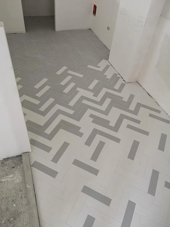 pavimentazione a spina di pesce appena messa con effetto decorativo che sfoma in due colori dal grigio al bianco