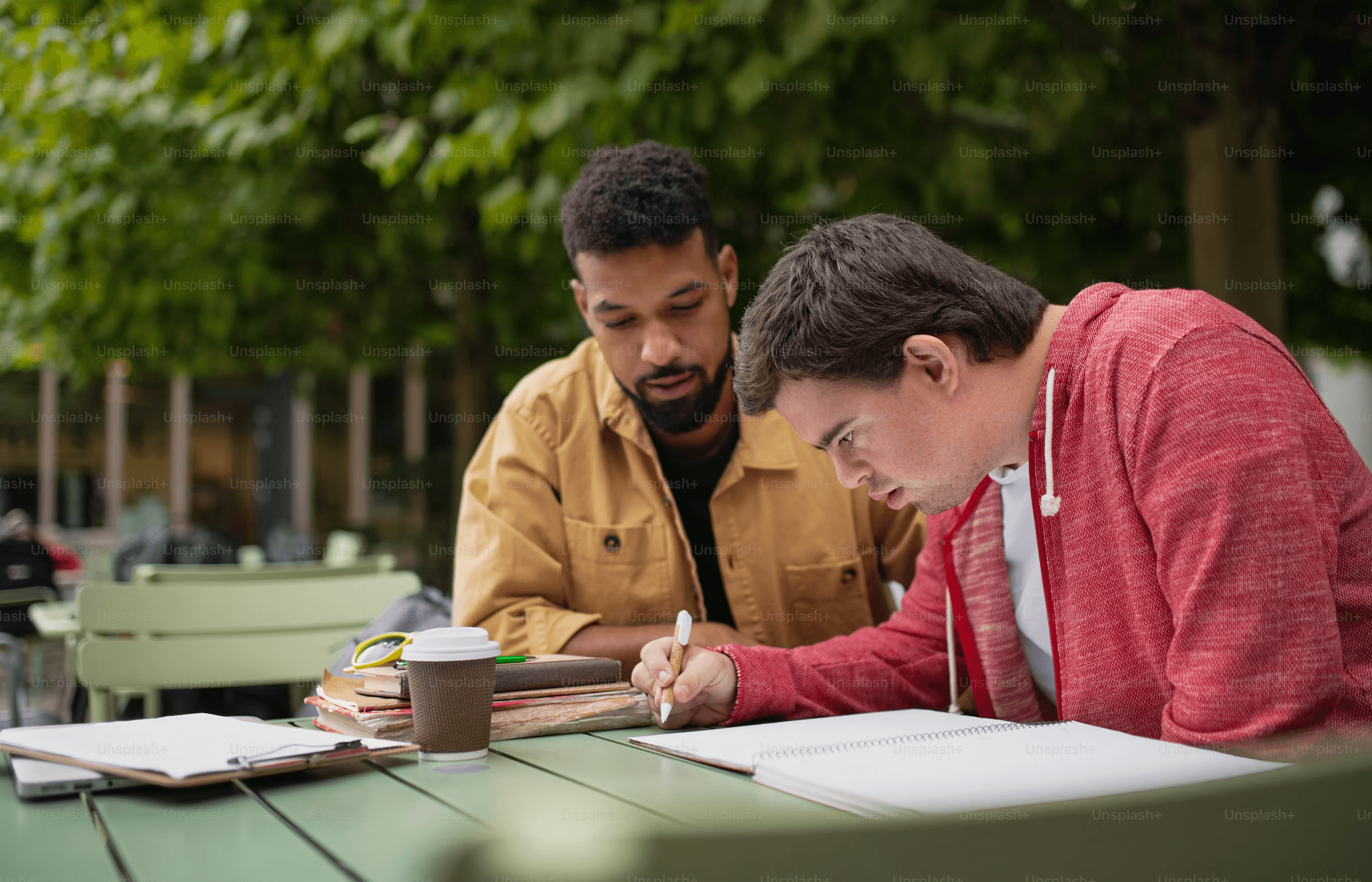 High school student conducting comparative literature research with a PhD mentor at a university library