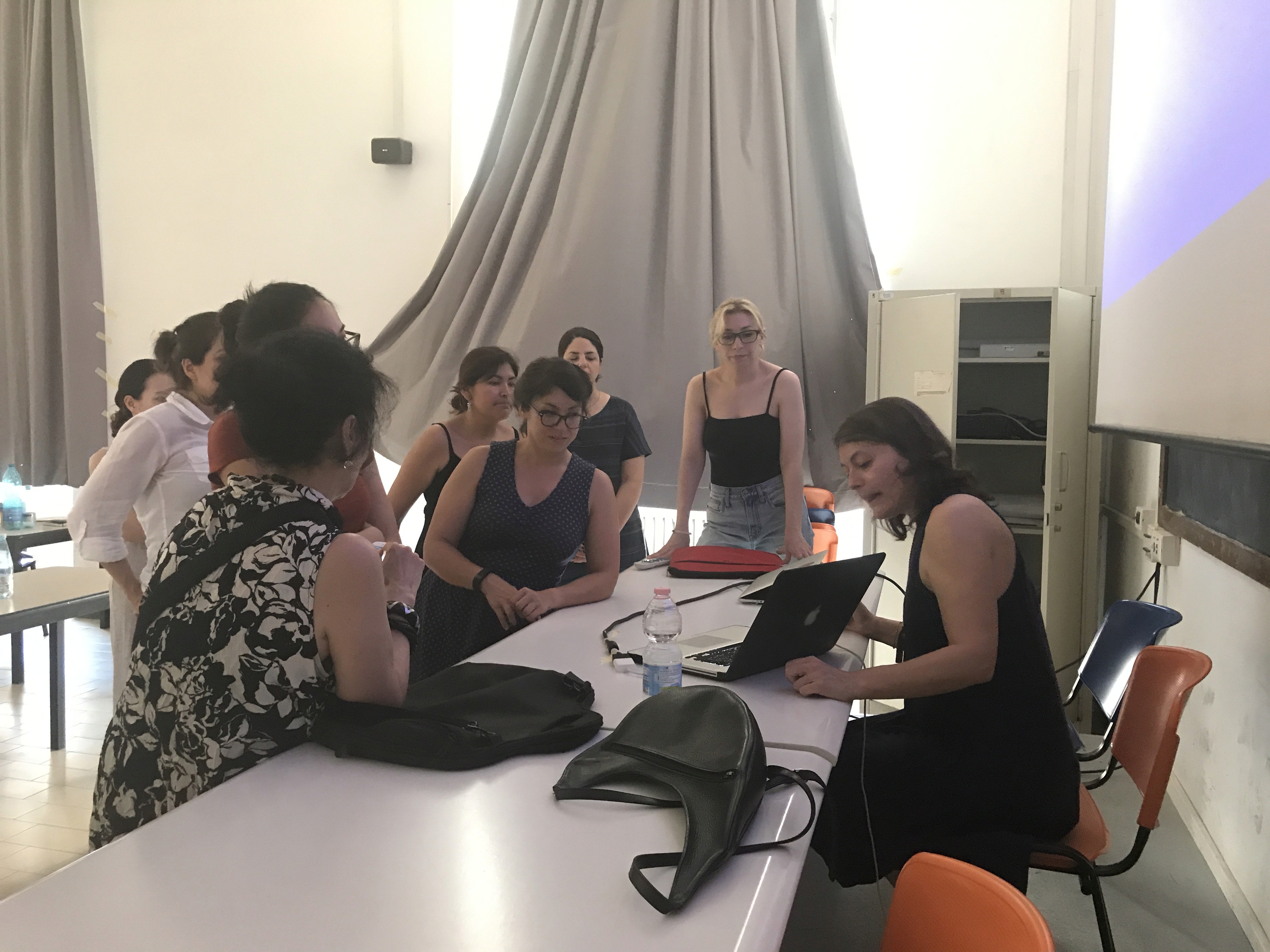 A photography showing women looking at a laptop in a conference room.