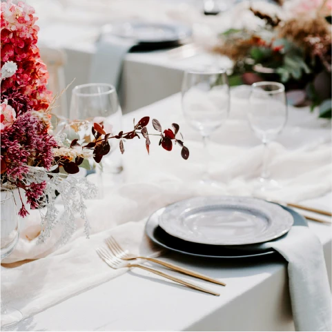 a dining room with tables and chairs with white tablecloths