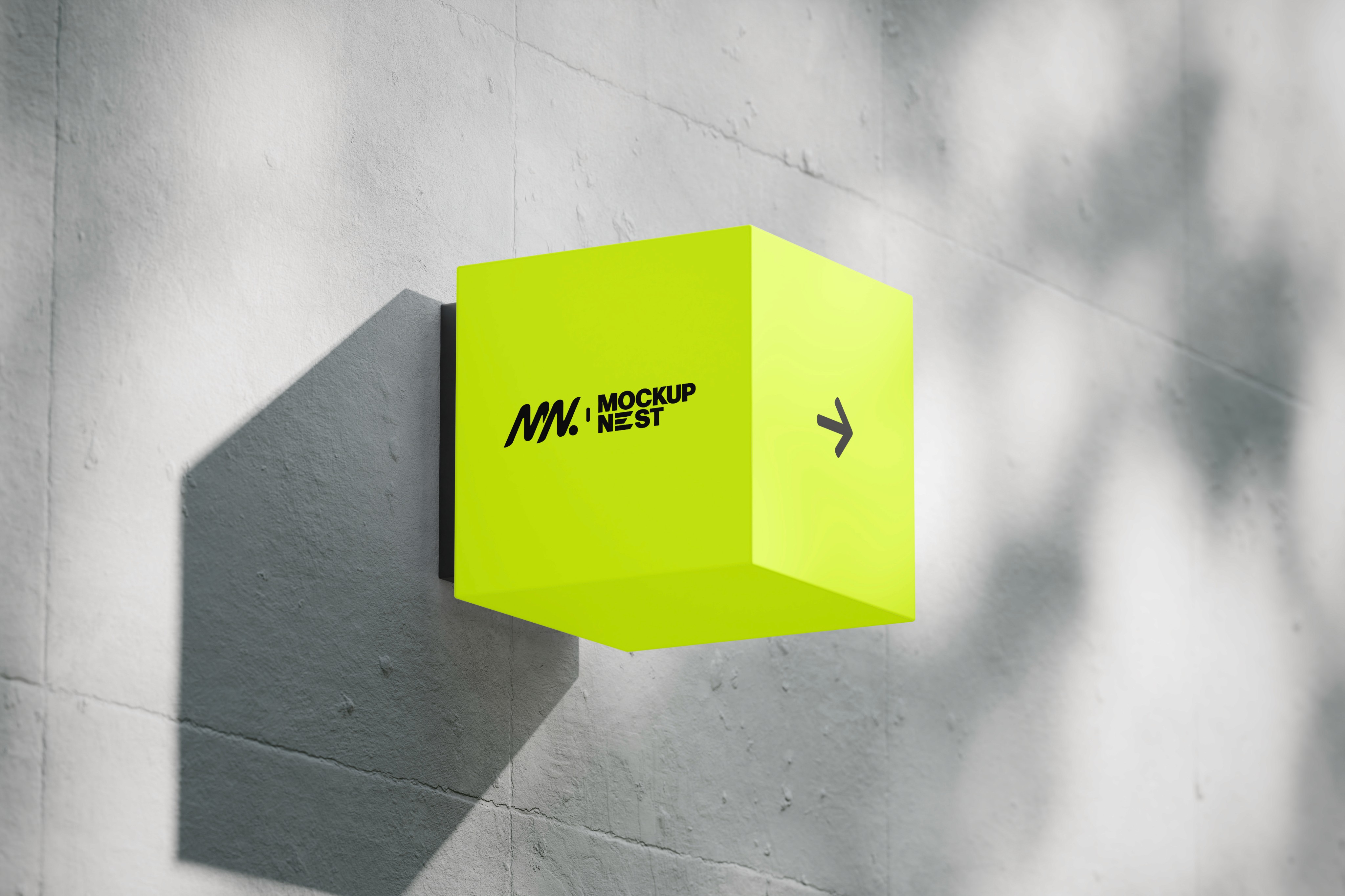 Bright neon-yellow cube sign mounted on a wall casting a shadow.