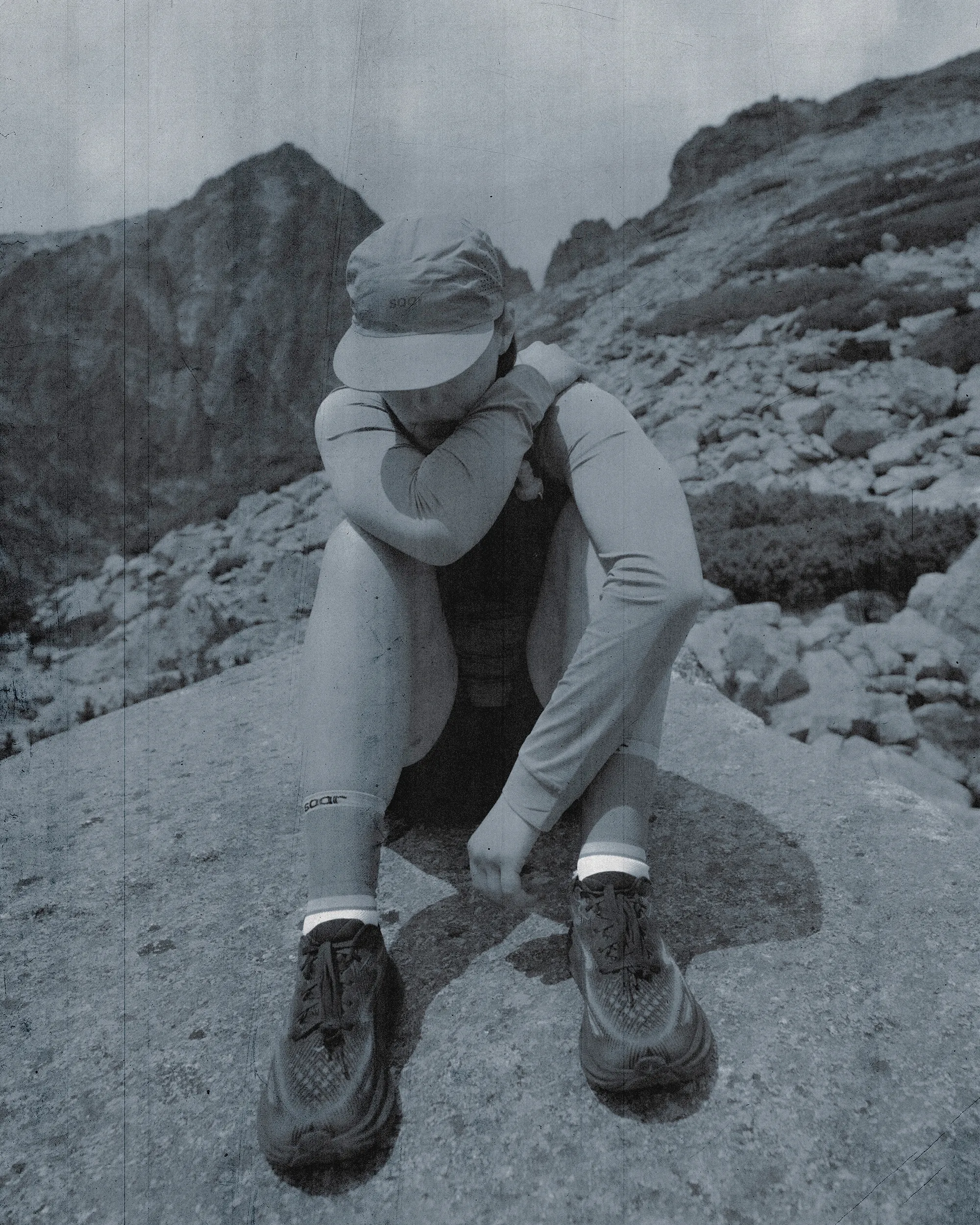 picture of a woman trail running, sitting on a rock.