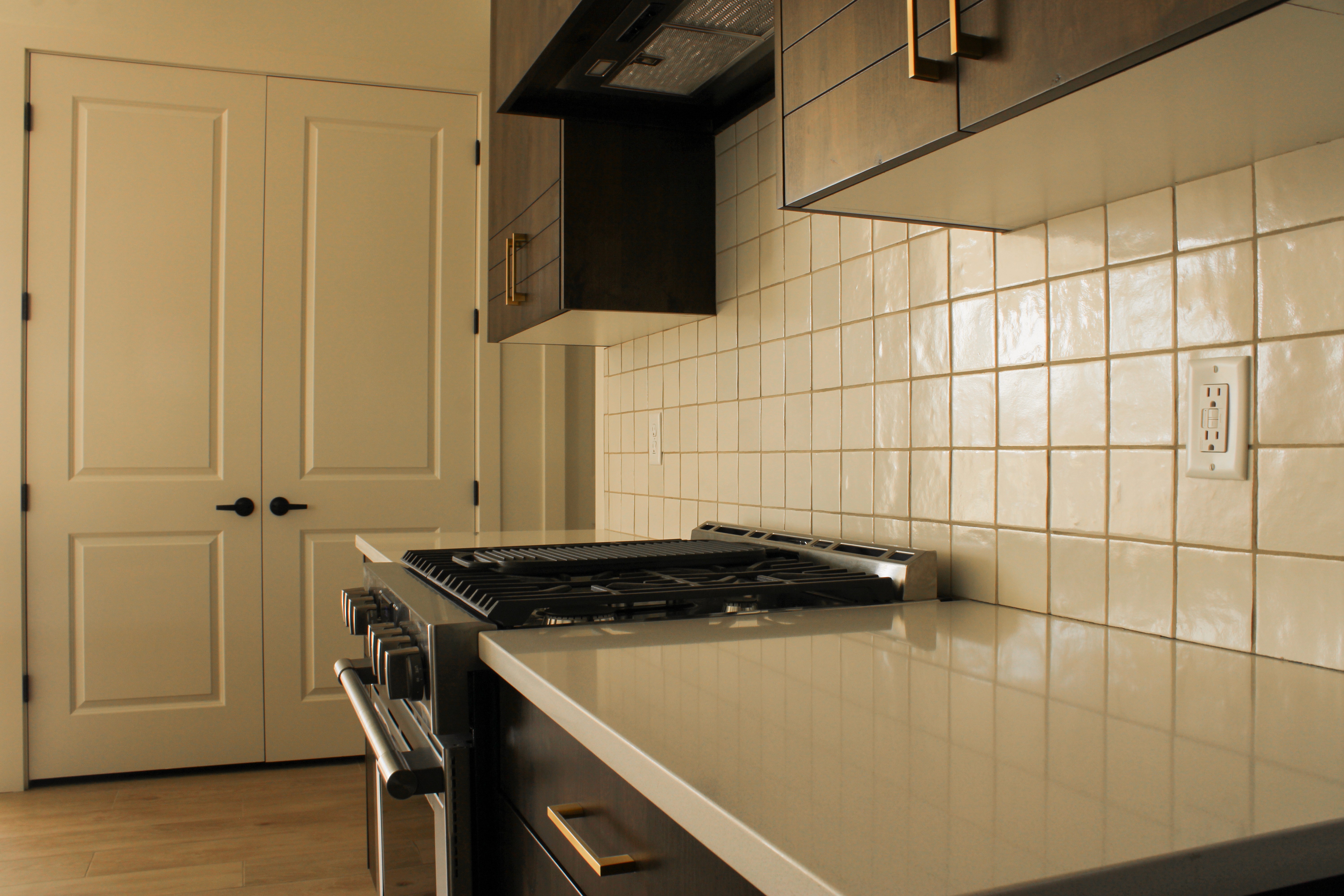 Close-up of tile backsplash, wood cabinetry, and gold hardware in Hurricane, Utah.