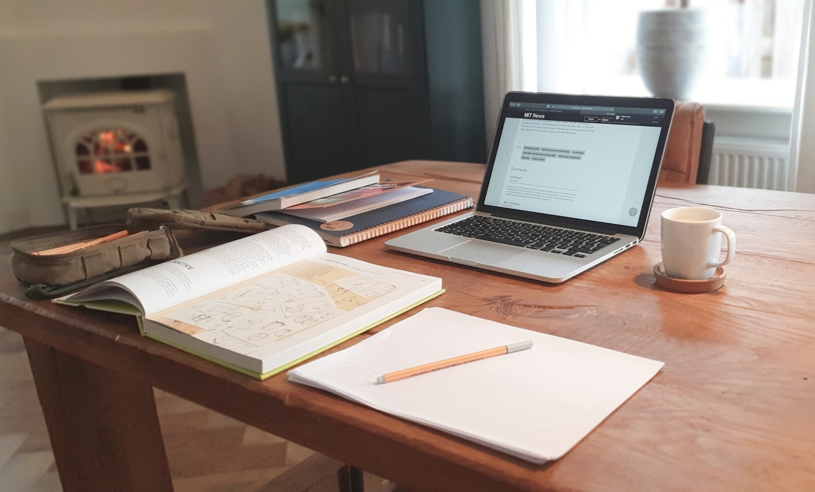 Laptop on a desk beside an open notebook, representing learning a new website builder