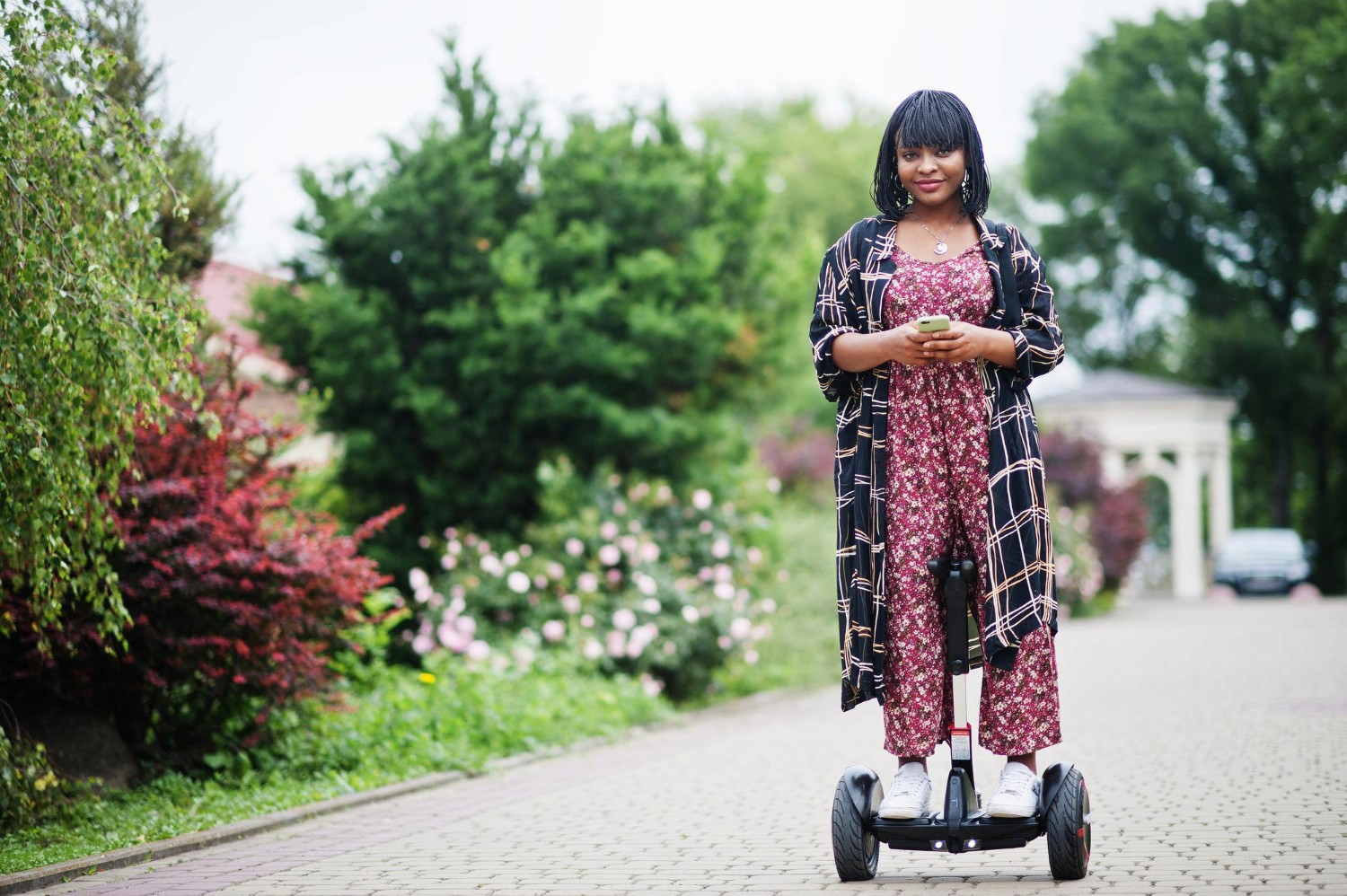 A woman rides a segway while exploring the outdoors. 