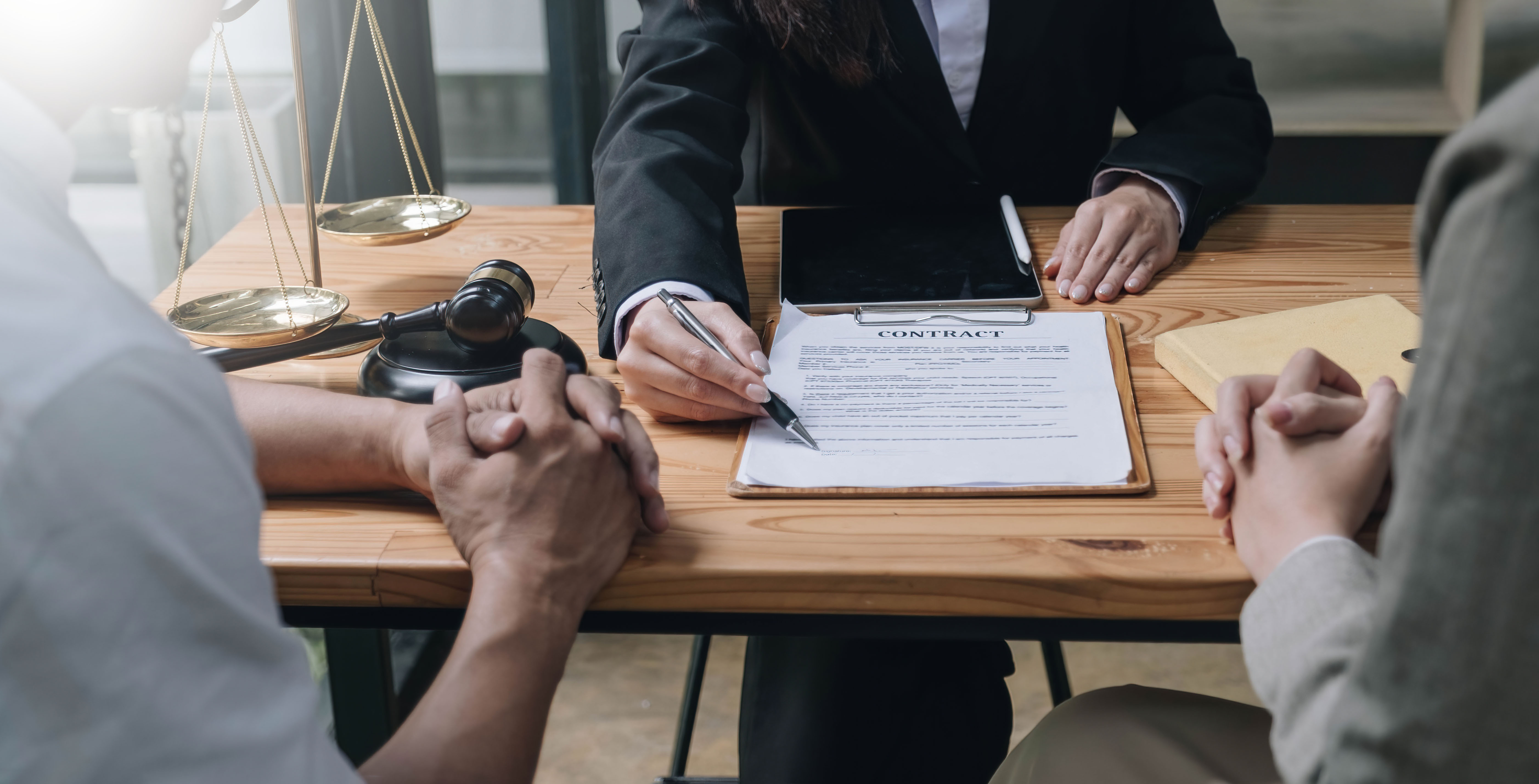 Attorney mediating between two spouses reviewing documents at a desk, representing the legal intersection of bankruptcy and divorce proceedings in Essex County, MA