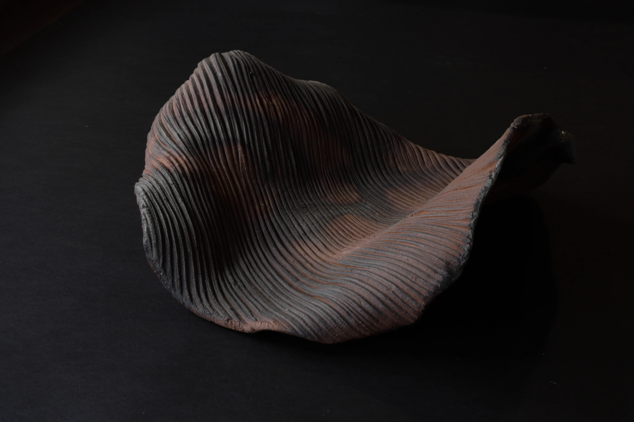 Bizen pottery ware on display againt a black backdrop