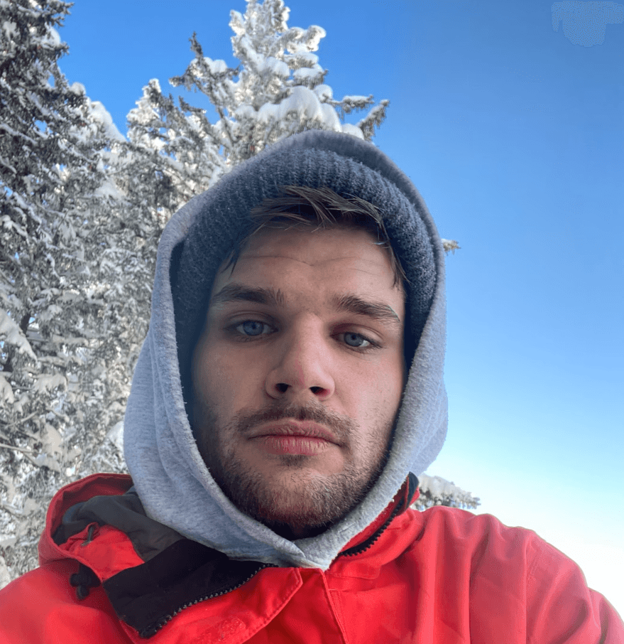 A thoughtful young person with dark hair gazes to the side, captured in soft black and white lighting.