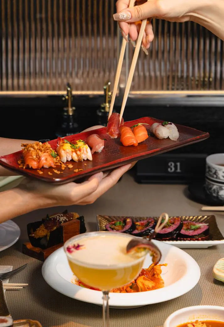 A plate of sushi shared with chopsticks