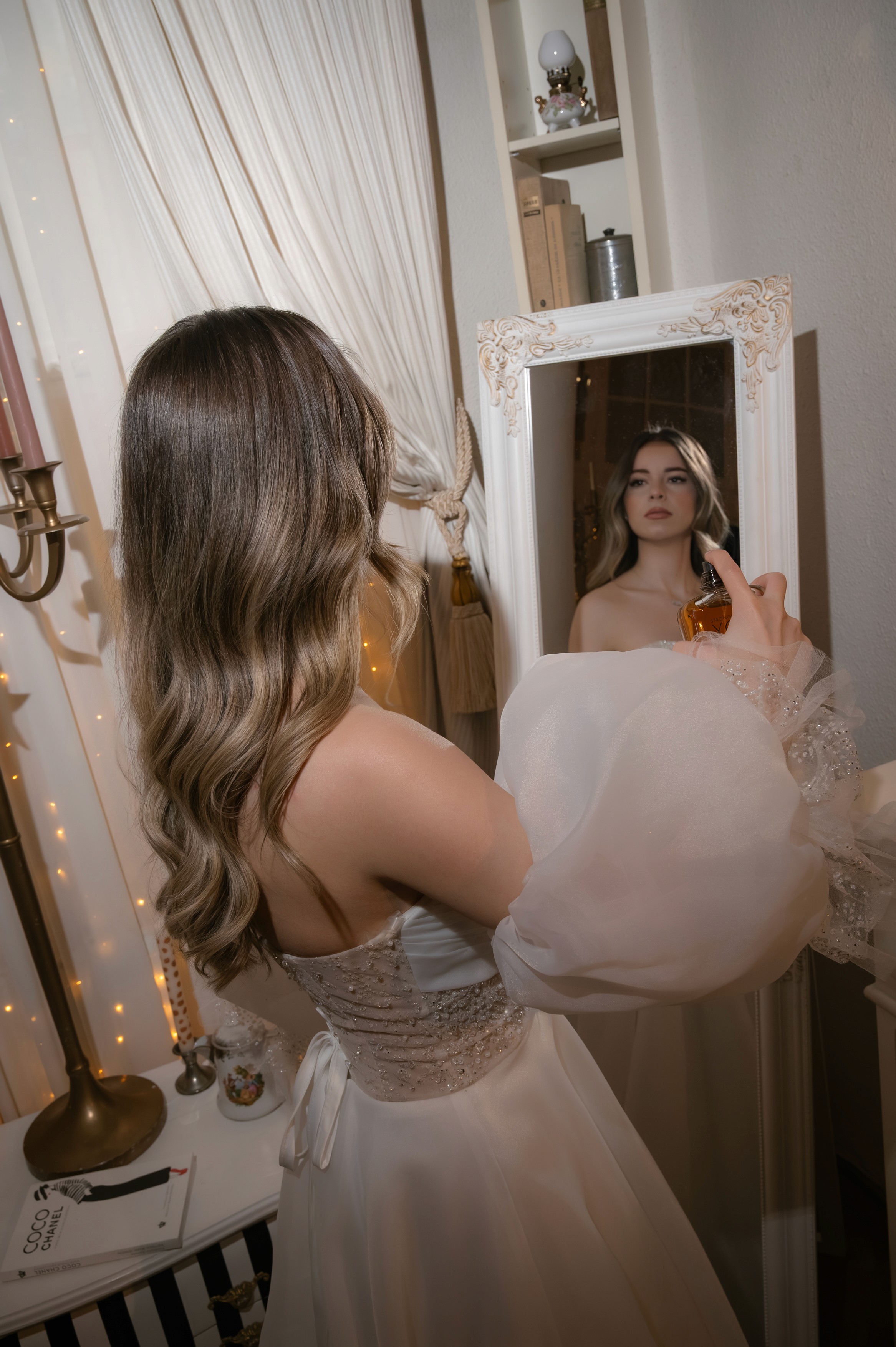 Mireasă în rochie albă cu mâneci voluminoase, lângă șemineu alb, fotografie documentară nuntă București