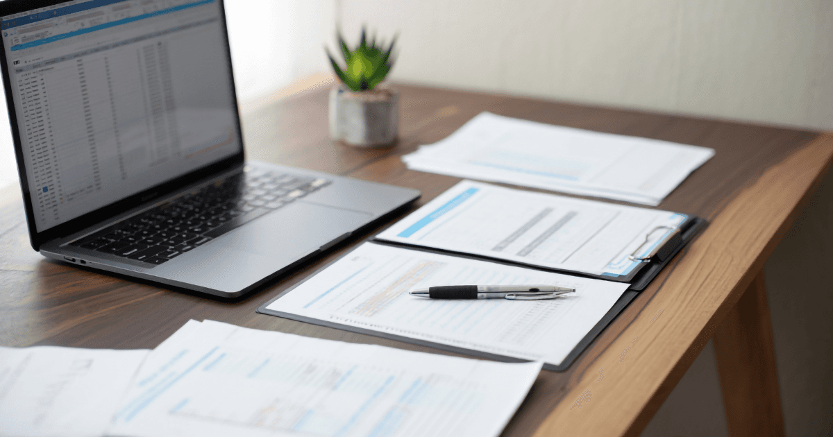 Tall grasses or reeds silhouetted against a hazy, golden sunrise or sunset.