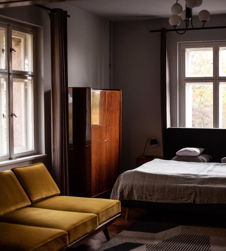 Łóżko, sofa, komoda w apartamencie w Villa Stara Apteka. Hotel dla grup w Srebrnej Górze