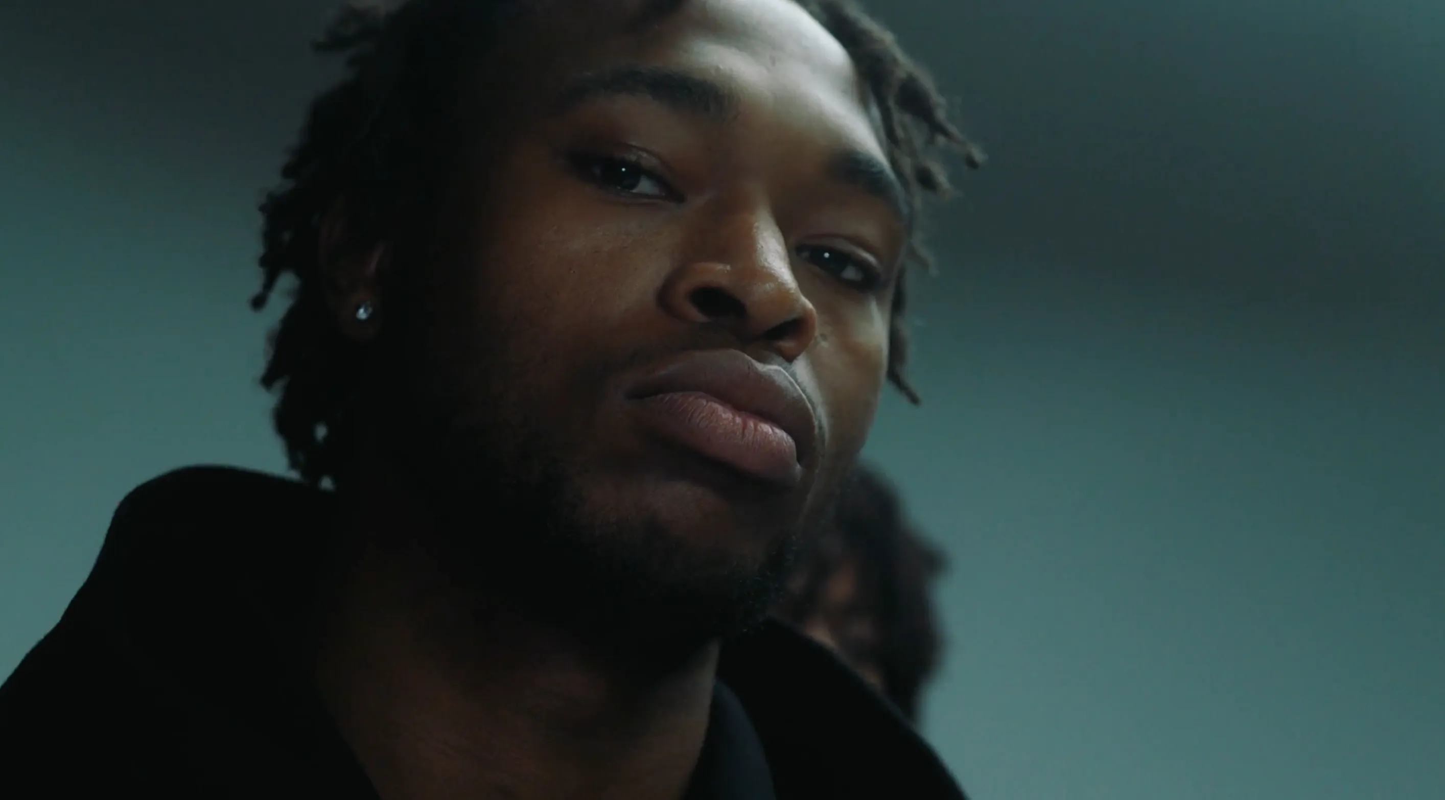 A man stood in a London studio staring at the camera having his photo taken