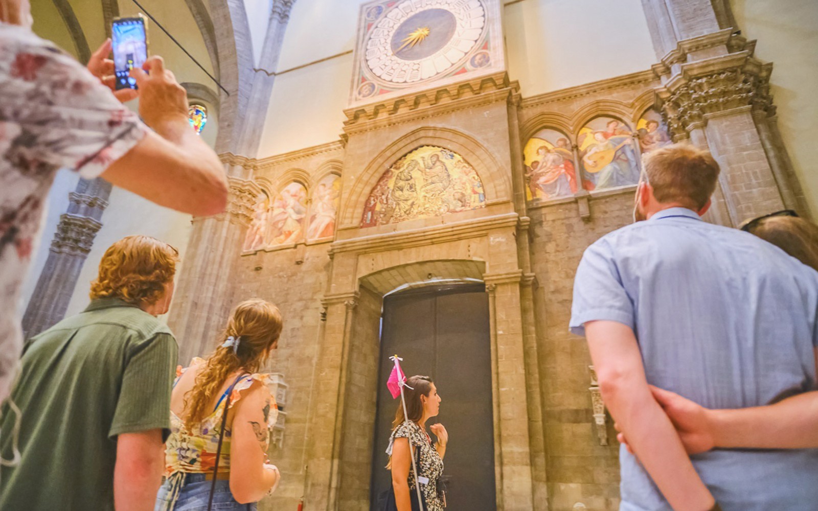 旅行团参观佛罗伦萨大教堂内的壁画和钟表。