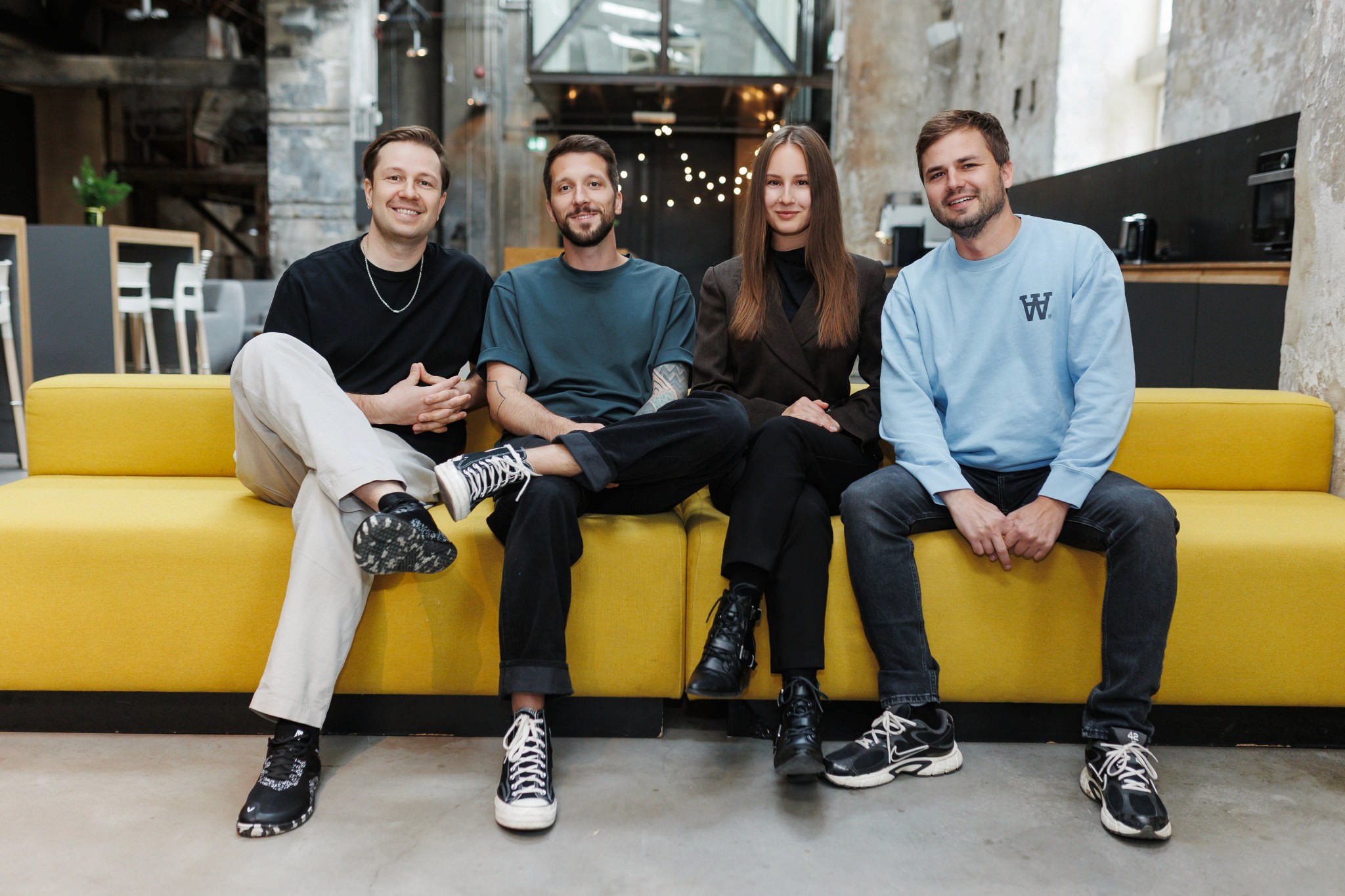 Team of five people standing together in a modern office