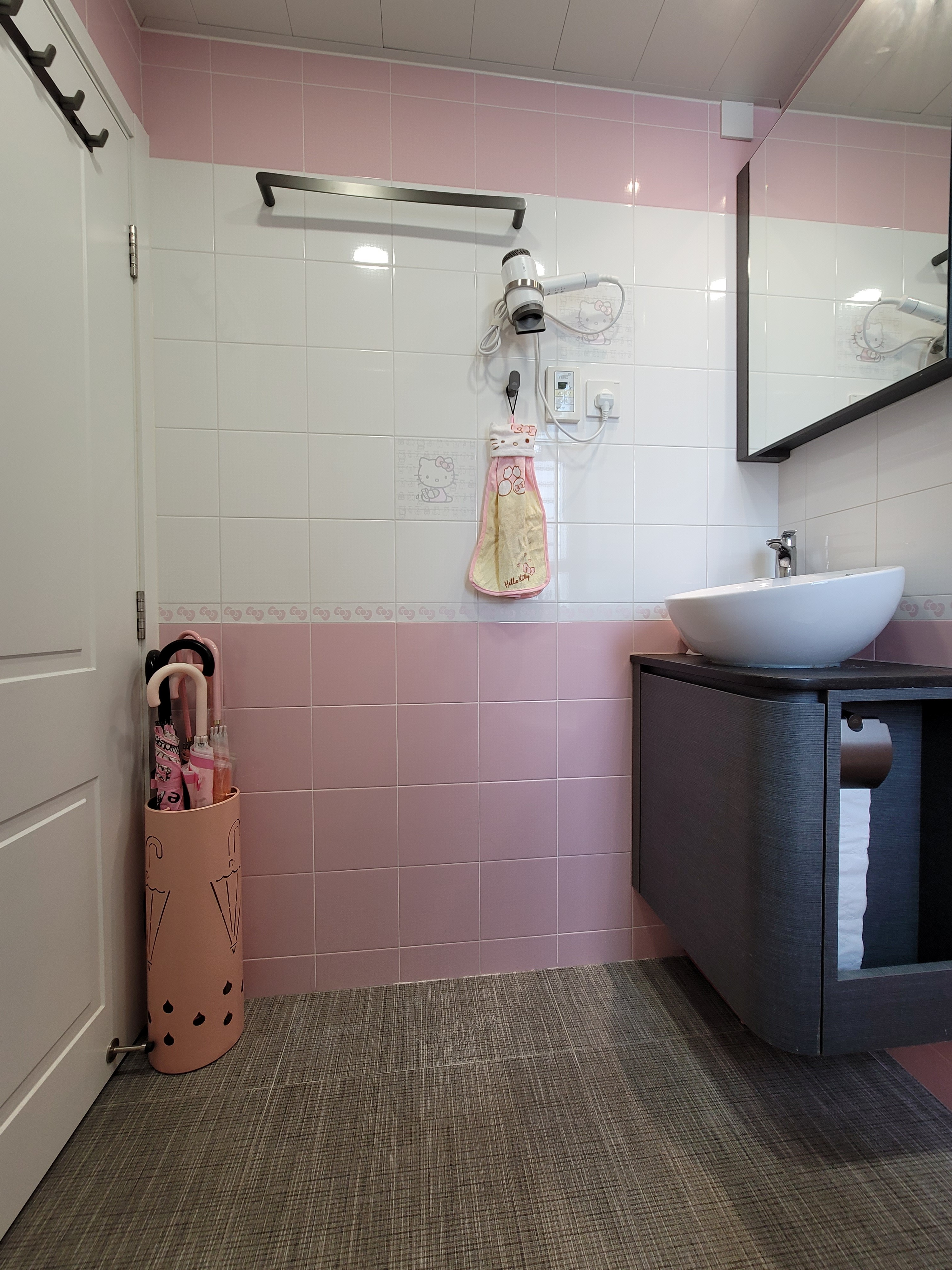 Functional small bathroom design with white ceramic toilet, round vessel sink, and gray cabinetry in Hoi Tat Estate residence.