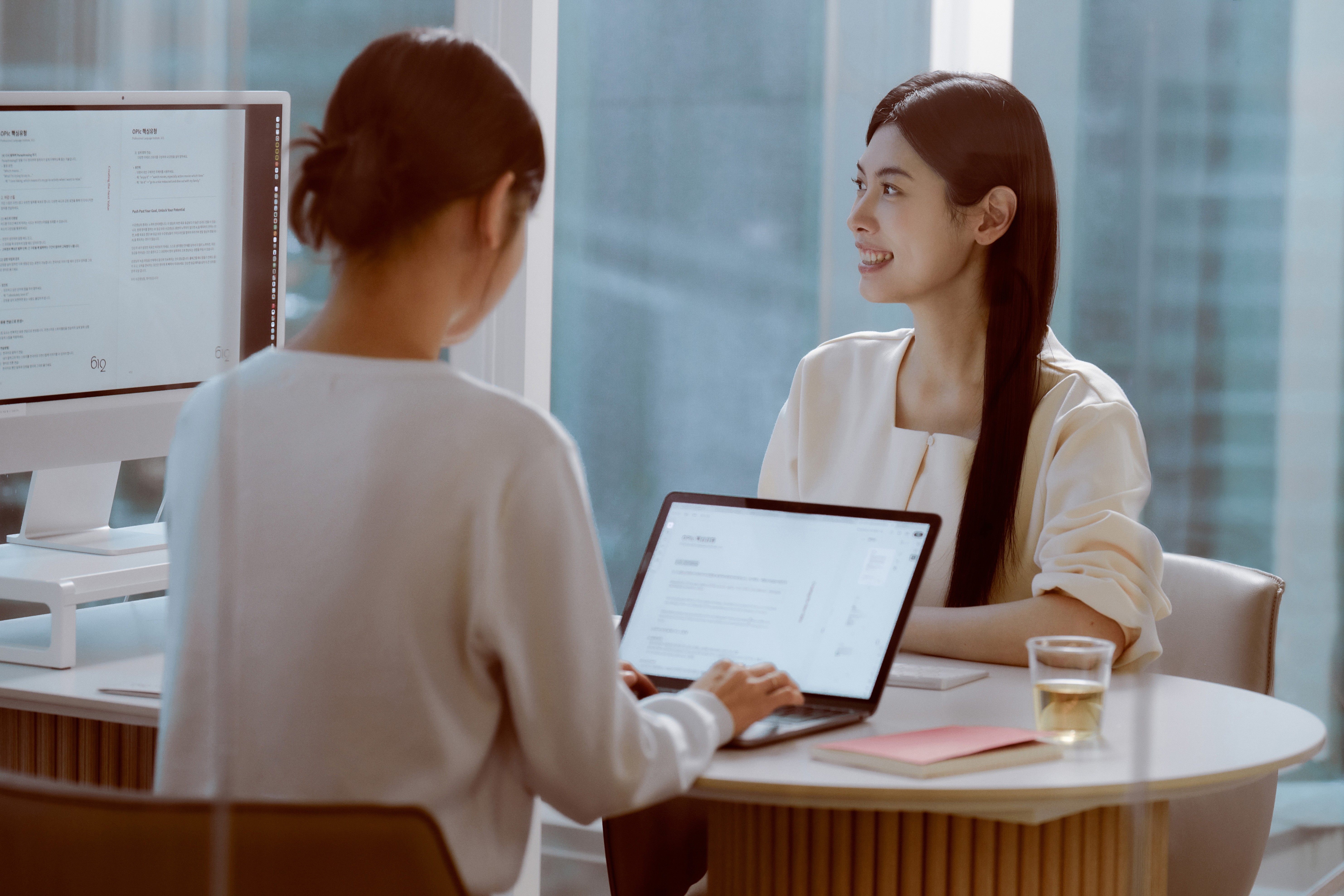 Two students smiling during a language learning session at 612 Academy, reflecting an engaging and human-centered learning experience.