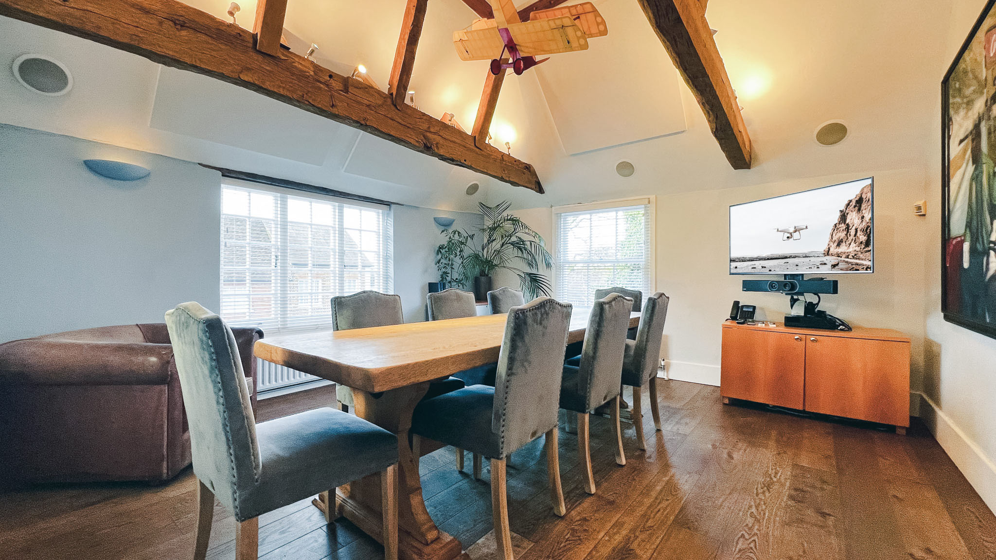 Modern red brick apartment or office building viewed from below against a blue sky, showcasing its geometric architecture with evenly spaced windows and balconies.