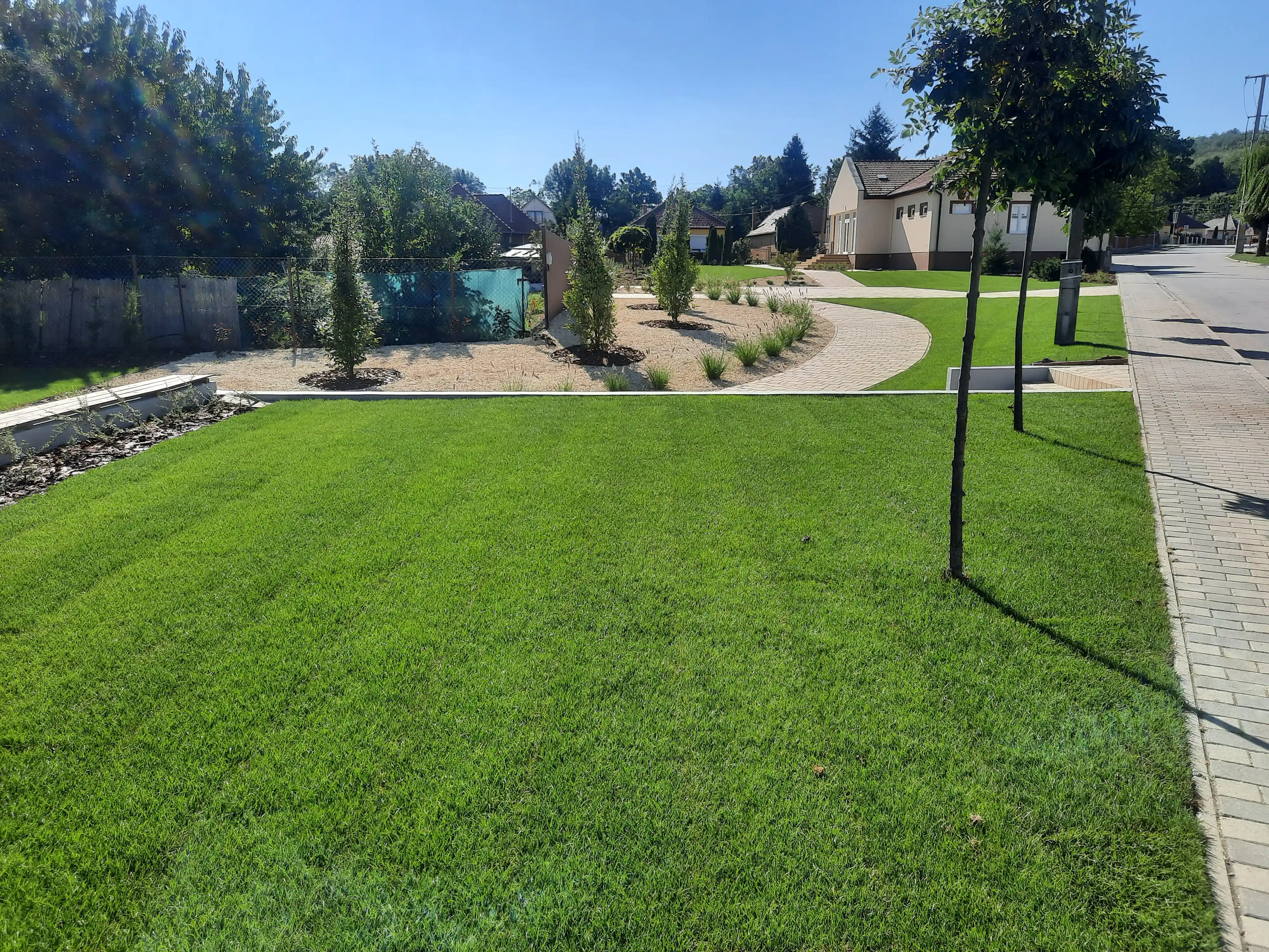 Közpark kivitelezés kavicságyakkal és dísznövényekkel