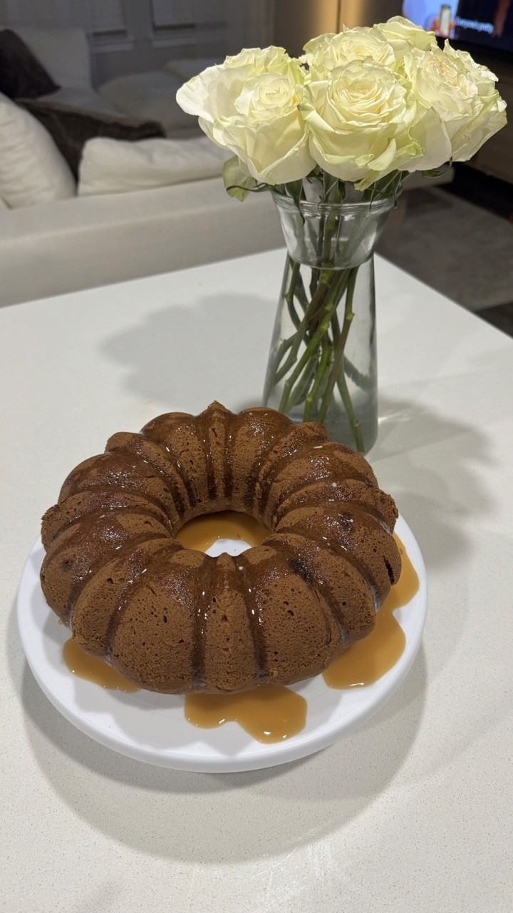 Bundt cake drizzled with earl grey flavored glaze next to vase of white roses – homemade earl grey bundt cake dessert Wellness by Suhey