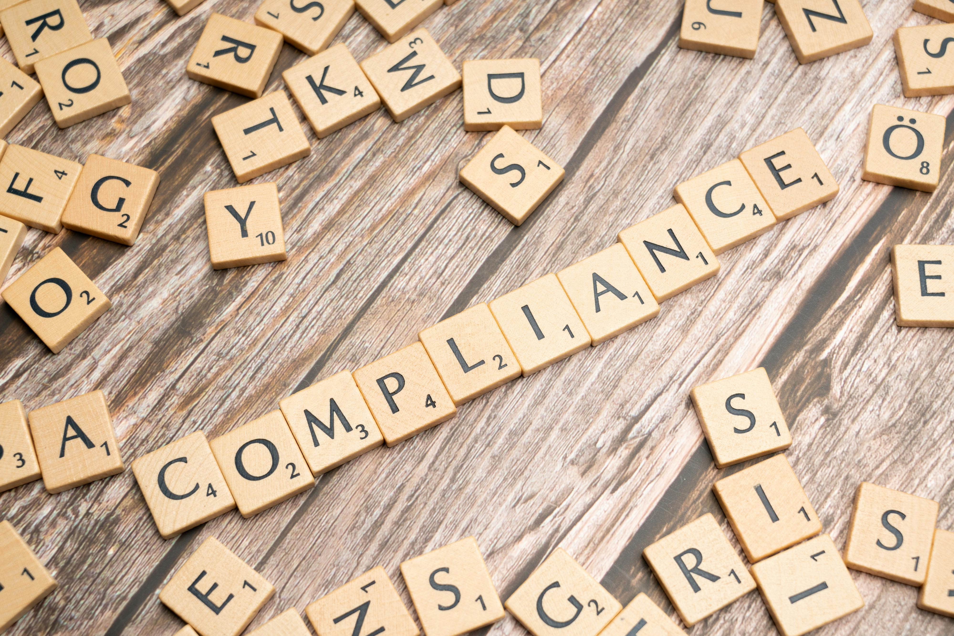 The word compliance in scrabble pieces