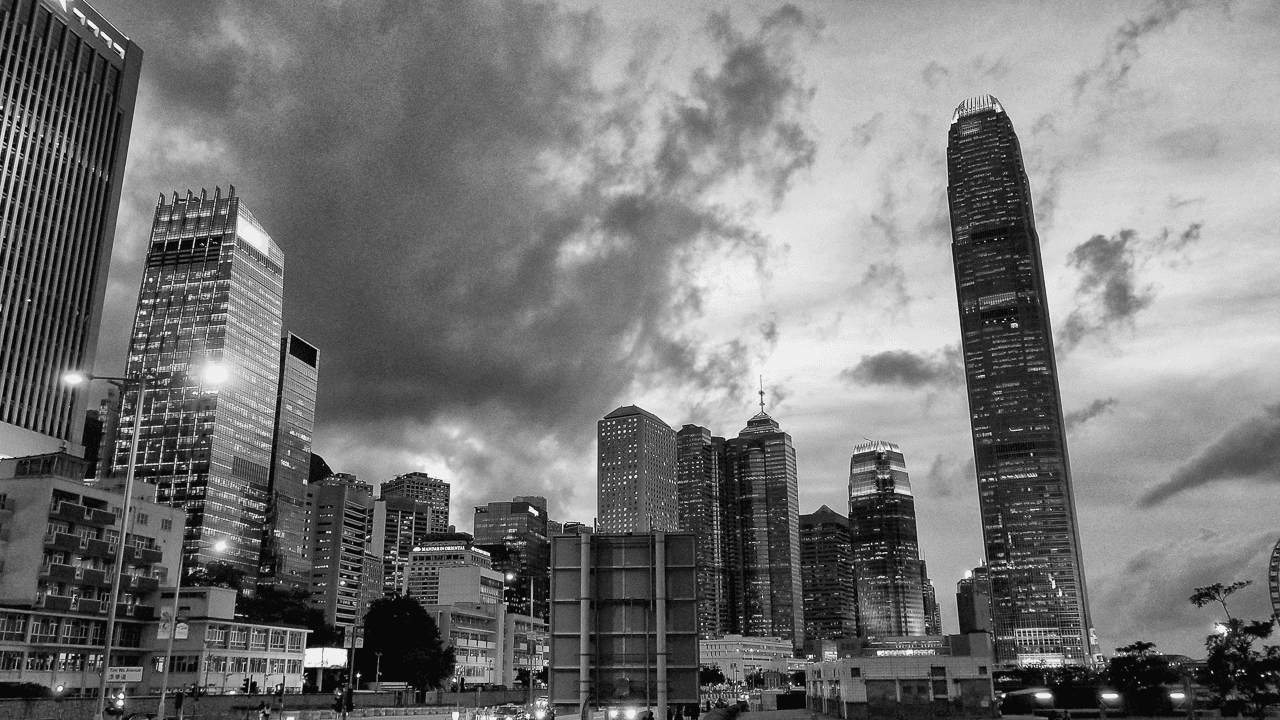 Black and white cityscape of Hong Kong’s financial center, featuring the IFC tower, symbolizing international corporate law and business growth.