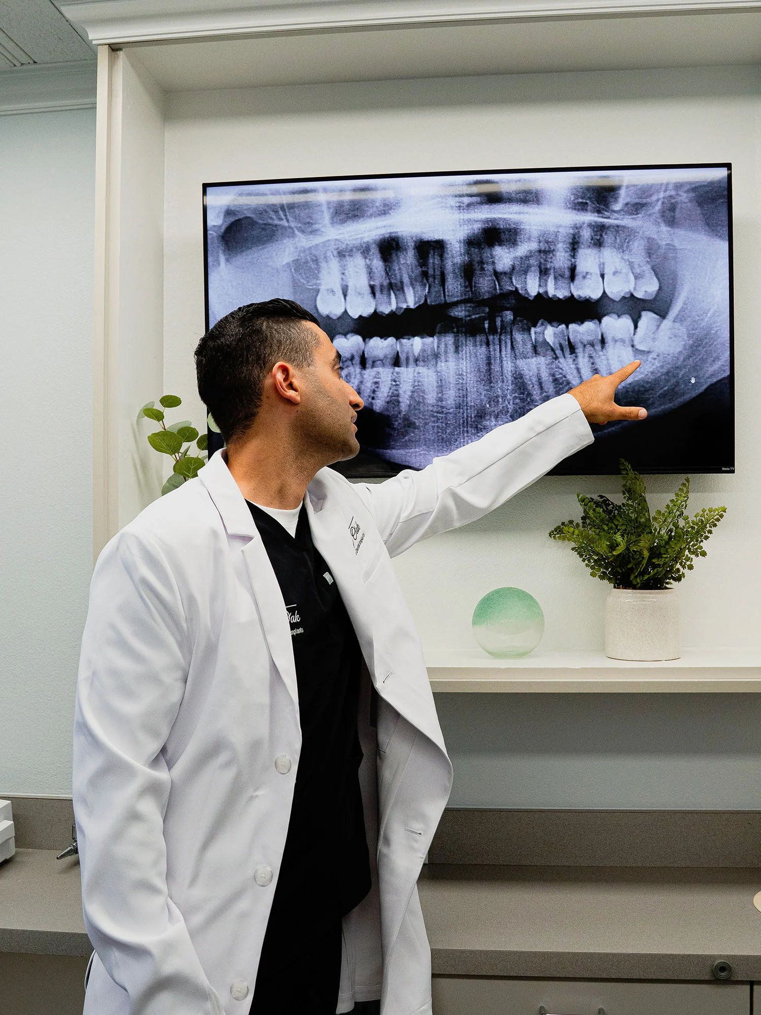 Dr. Justin Nassiri reviewing a patient’s panoramic dental X-ray during a consultation at an oral surgery practice in Fresno, CA
