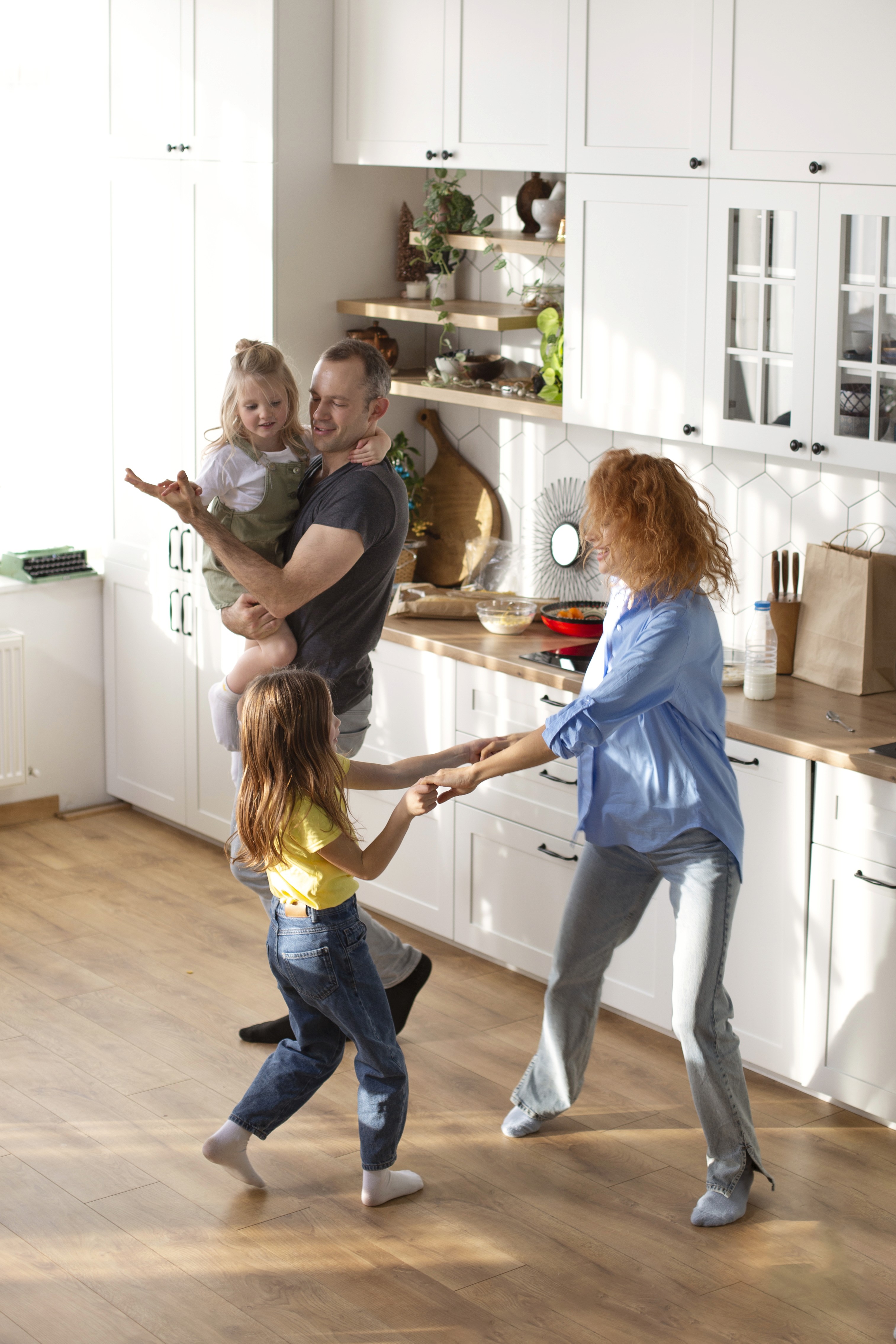 Kids dancing in a bright Brisbane kitchen on slip-resistant hybrid flooring that handles spills and busy family movement without worry.