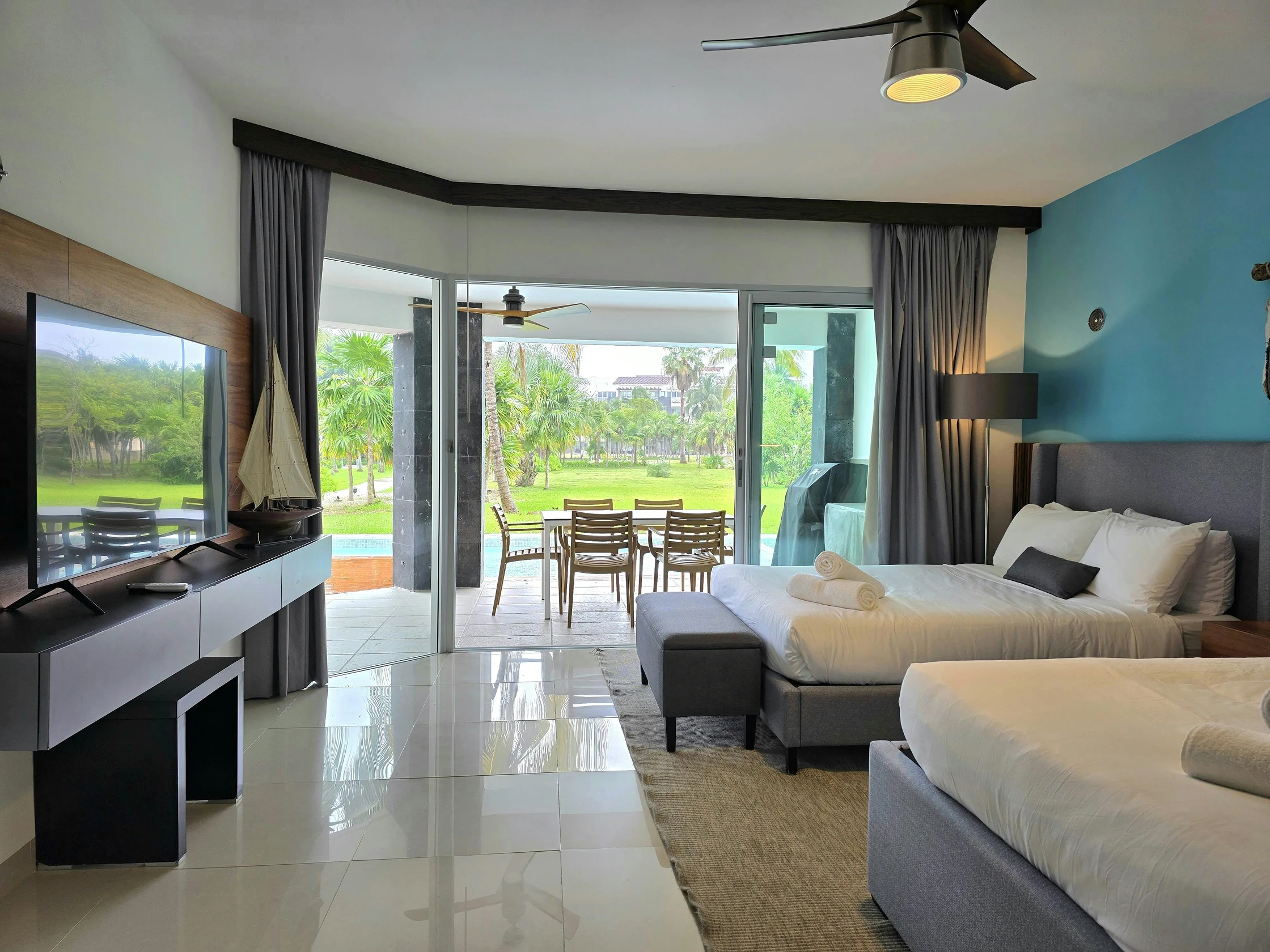 Spacious family suite with multiple beds, a sitting area, and direct access to an outdoor terrace.